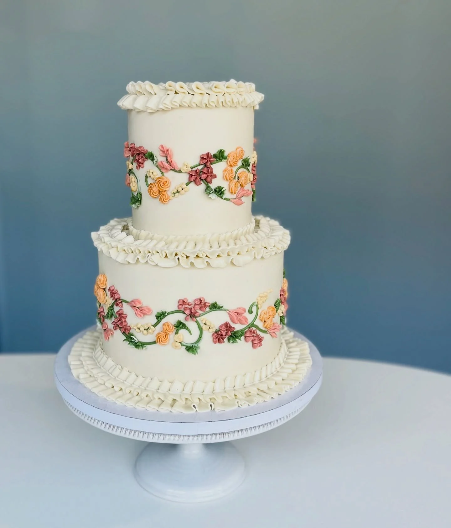 I just love this design and all the variations we&rsquo;ve been able to create with it. Sitting at my workbench, piping tiny flowers and vines and ruffles, is definitely a favorite part of my work day (and a nice change from whirring mixers, hot oven