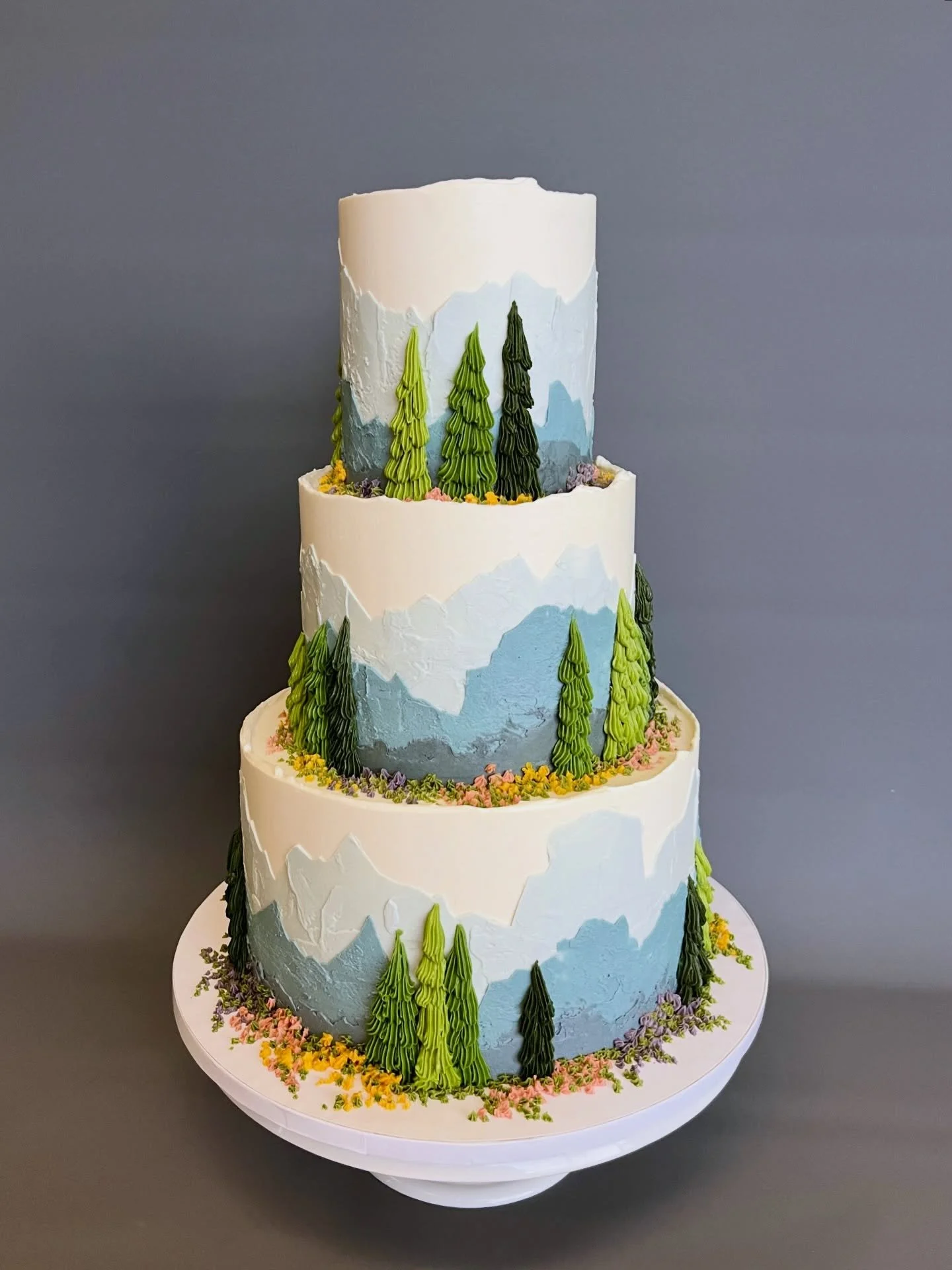 For Roshini and Usman, a three-tiered version of our best selling &ldquo;Mountain&rdquo; design, with abstract piped wildflowers added to evoke the iconic subalpine meadows at Paradise on Mt. Rainier. Truly a wonderful cake to work on that brought me