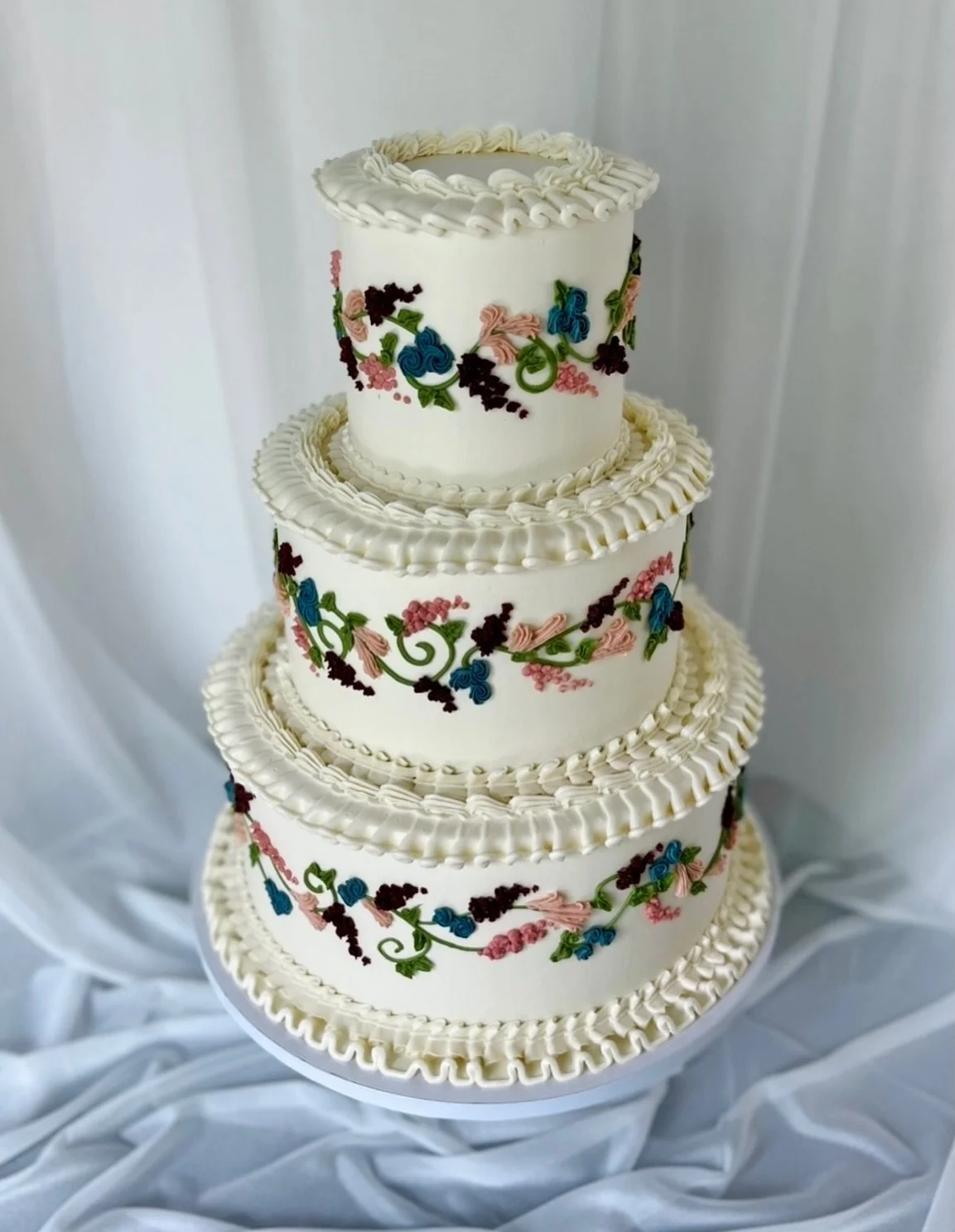 Two views of Chanel and Elijah&rsquo;s wedding cake, in studio and at the beautiful @theedgewater &mdash; one of many cakes made by my own hands and lovingly delivered last weekend (hello, wedding season!). Piped vintage ruffles and buttercream flora