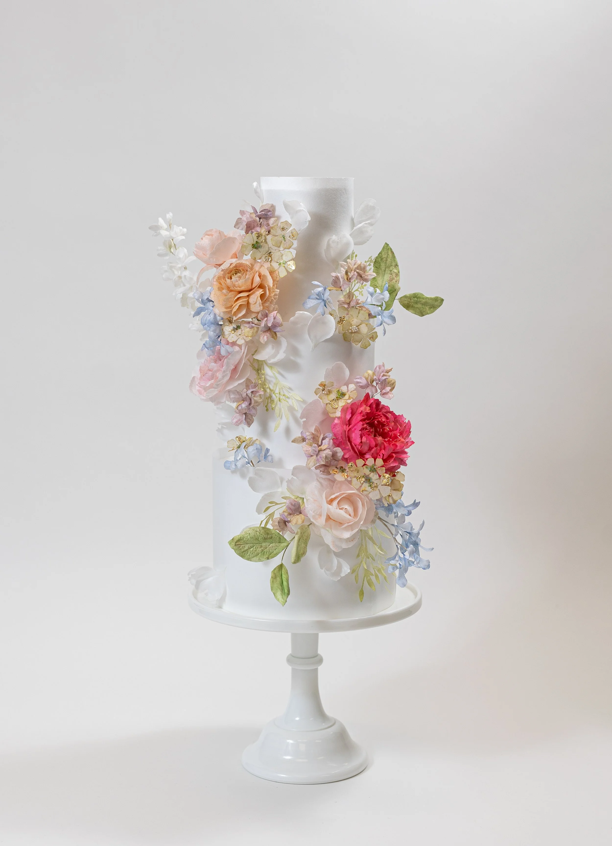 Custom four-tiered cake with handmade wafer paper flowers by Honey Crumb Cake Studio