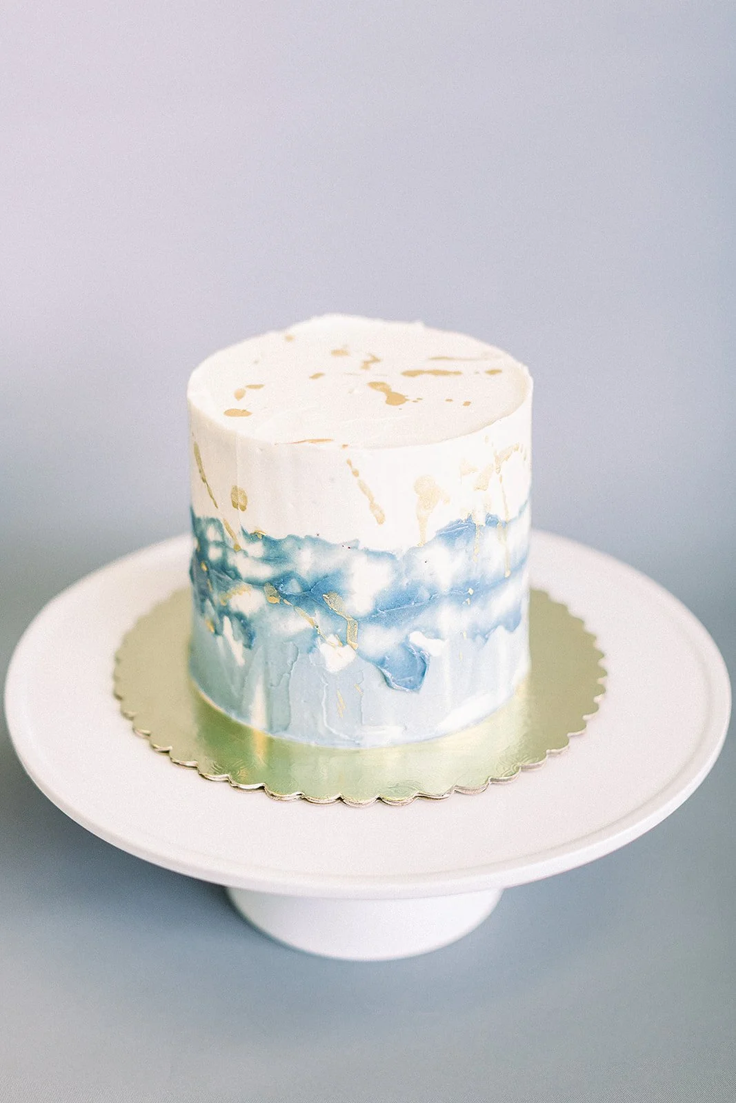 Beautiful textured blue buttercream cake with gold splatter made at a cake decorating workshop in Seattle