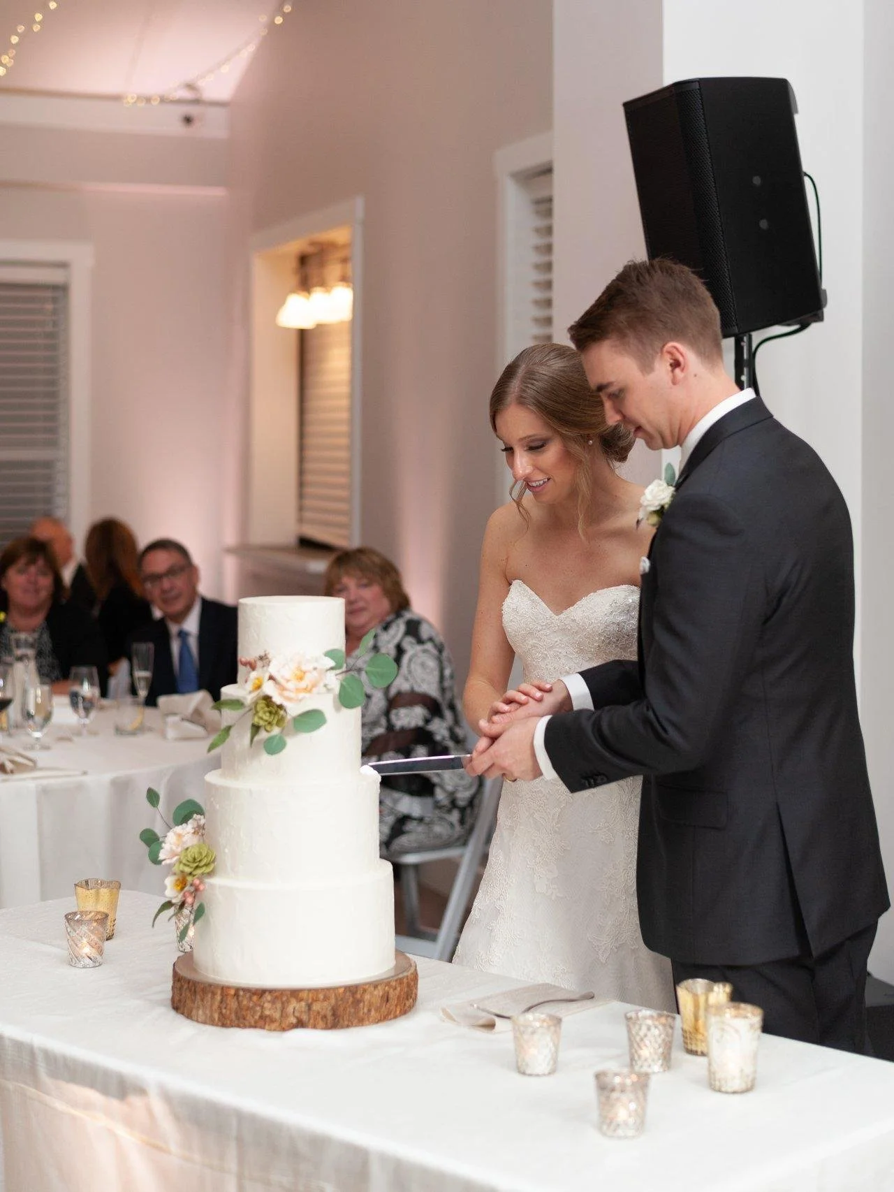 Couple cutting into four tiered wedding cake at Trinity Tree Farm Issaquah