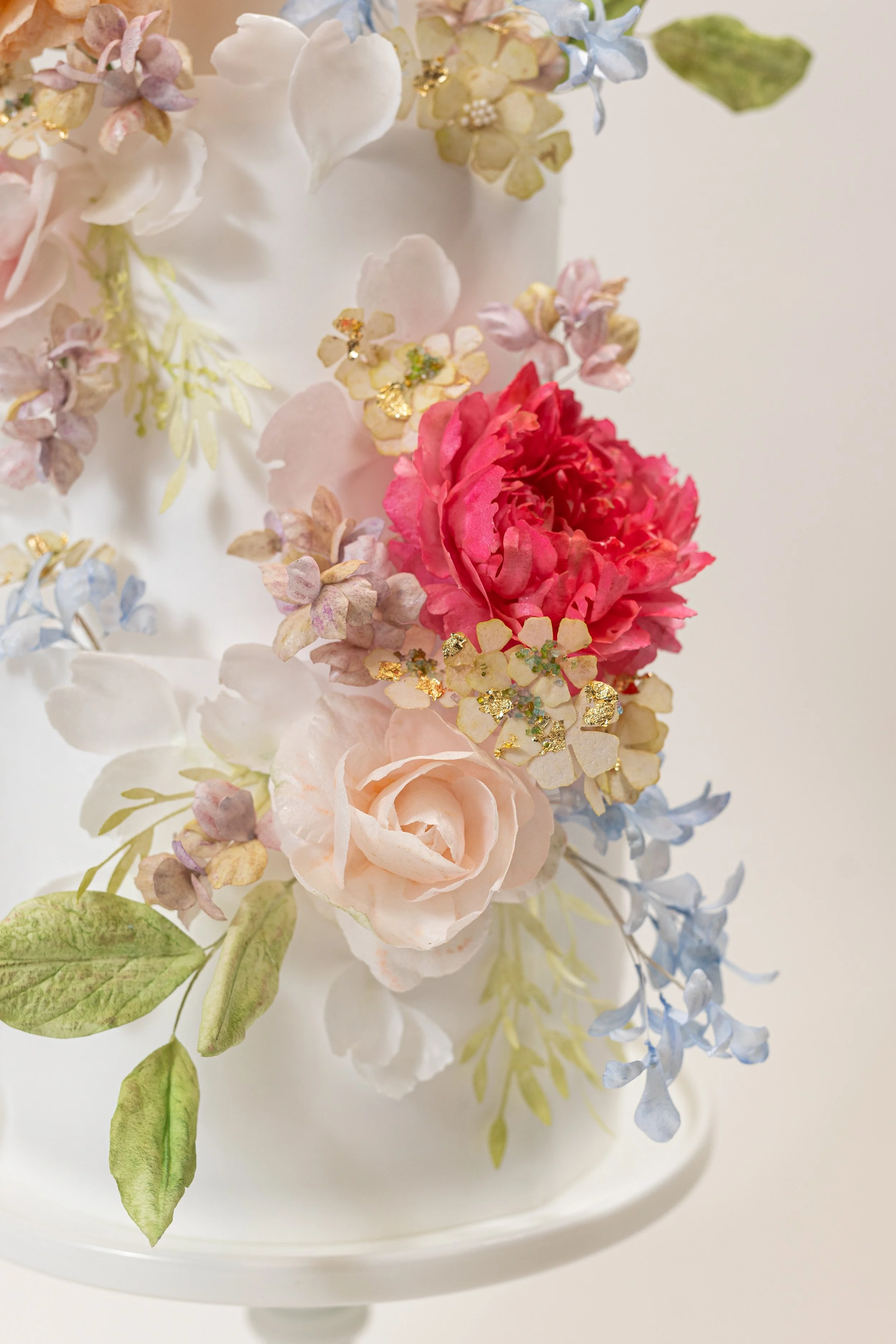 Custom four-tiered cake with handmade wafer paper flowers by Honey Crumb Cake Studio