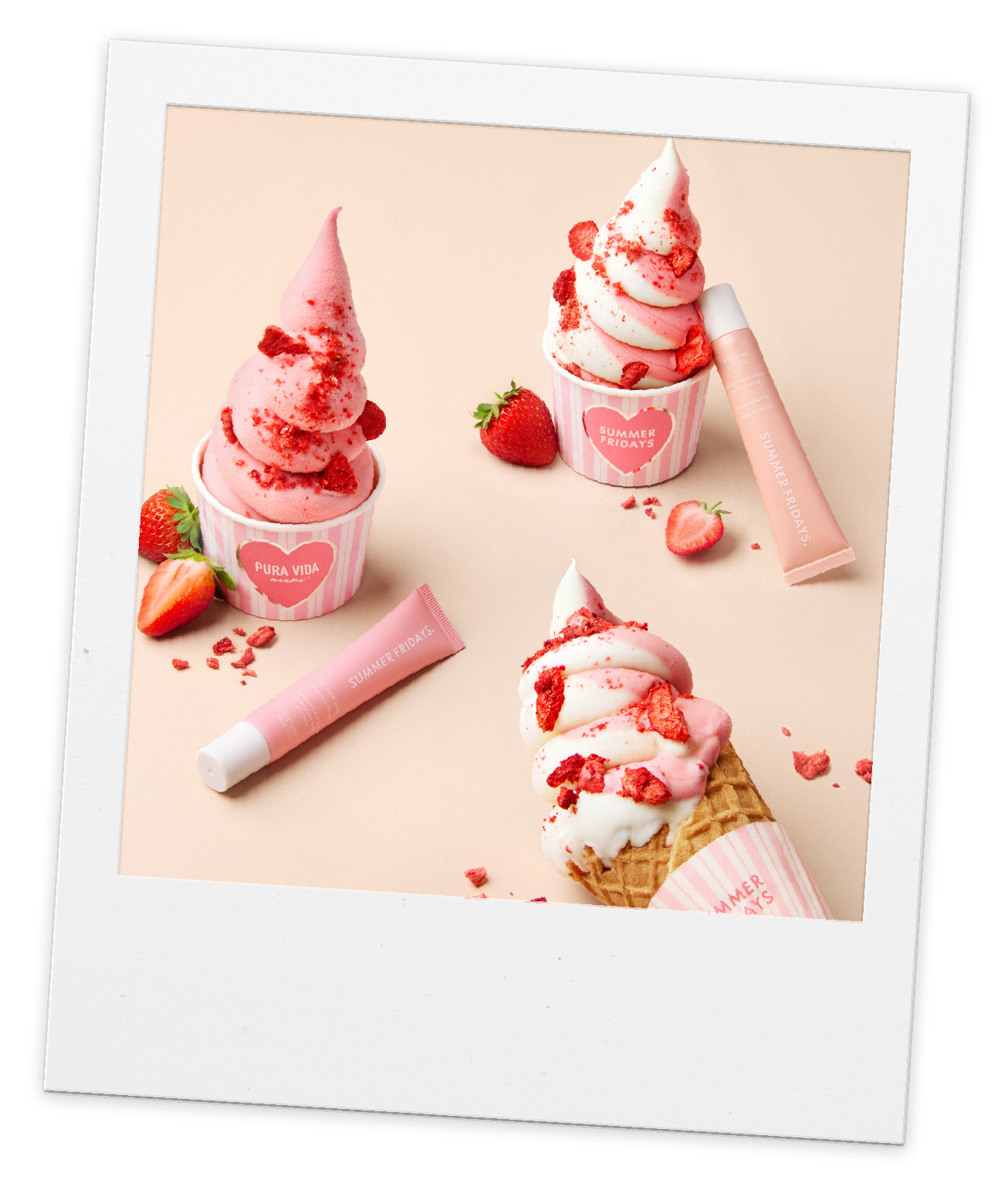 Gelato cups with strawberry soft serve surrounded by strawberries and pink lip balms.
