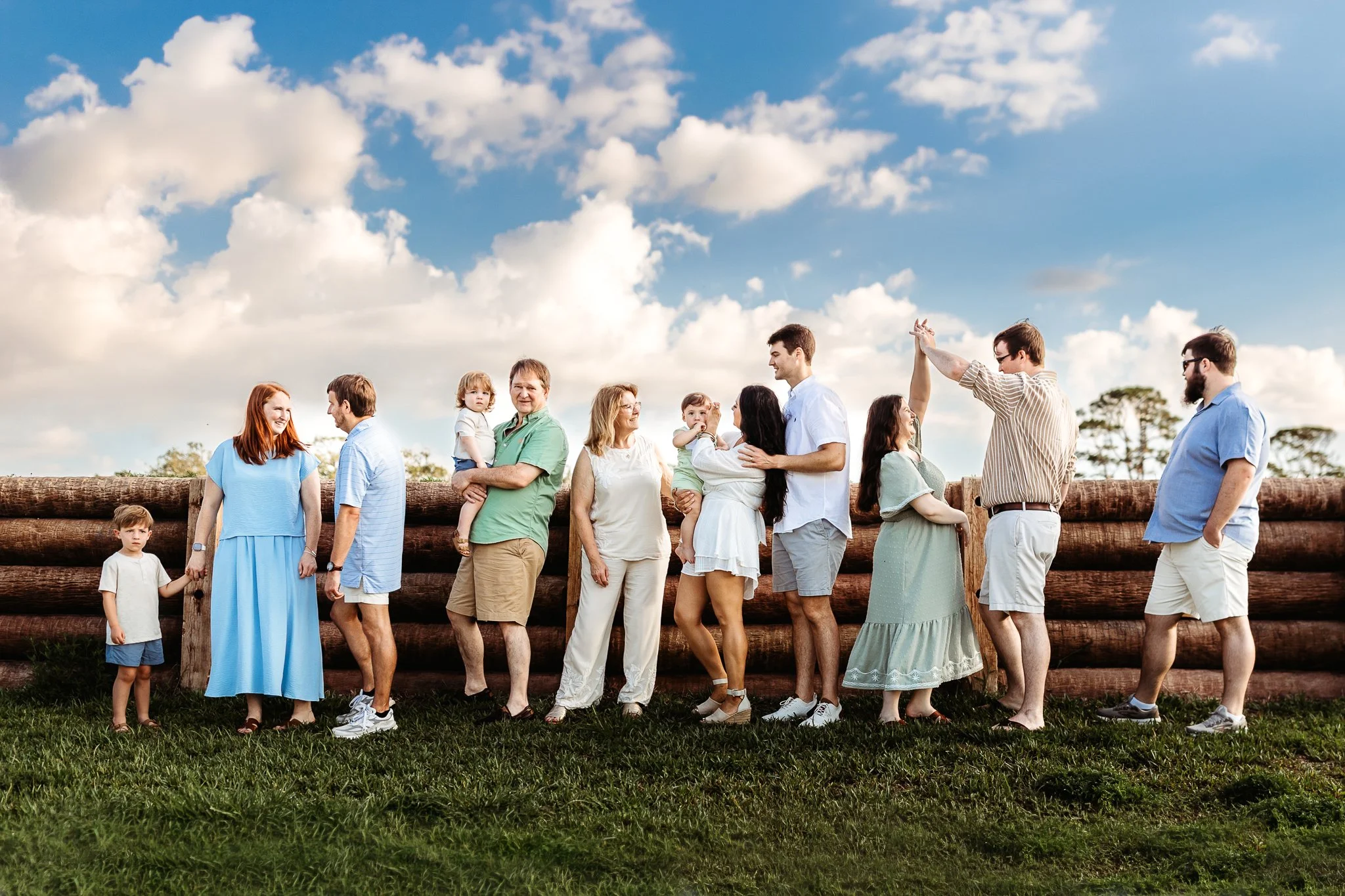 artistic image of a family at the fort along the log cannon wall with bright blue clouds in the sky