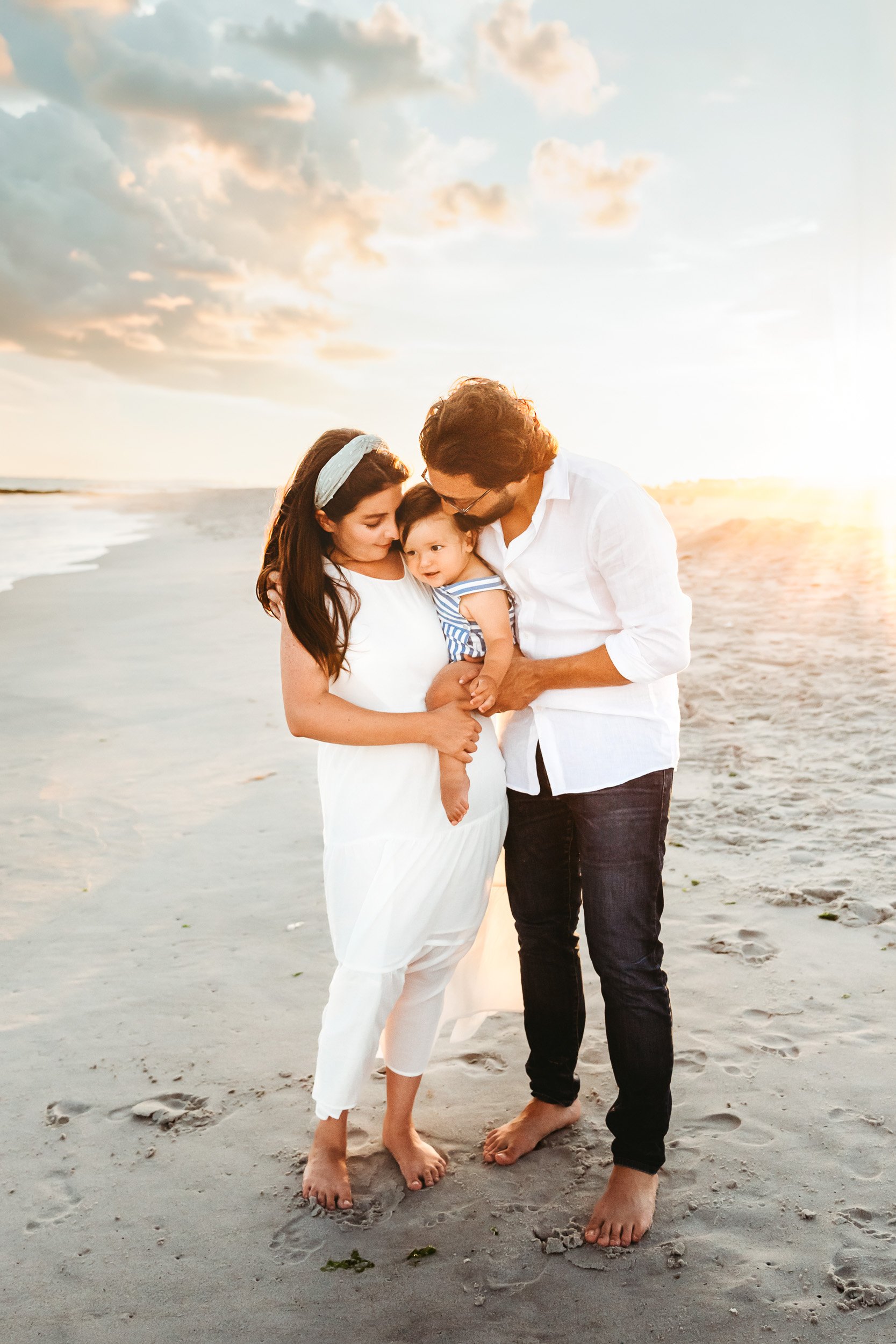 Family of three on the beach at sunset during a first birthday session in St. Augustine