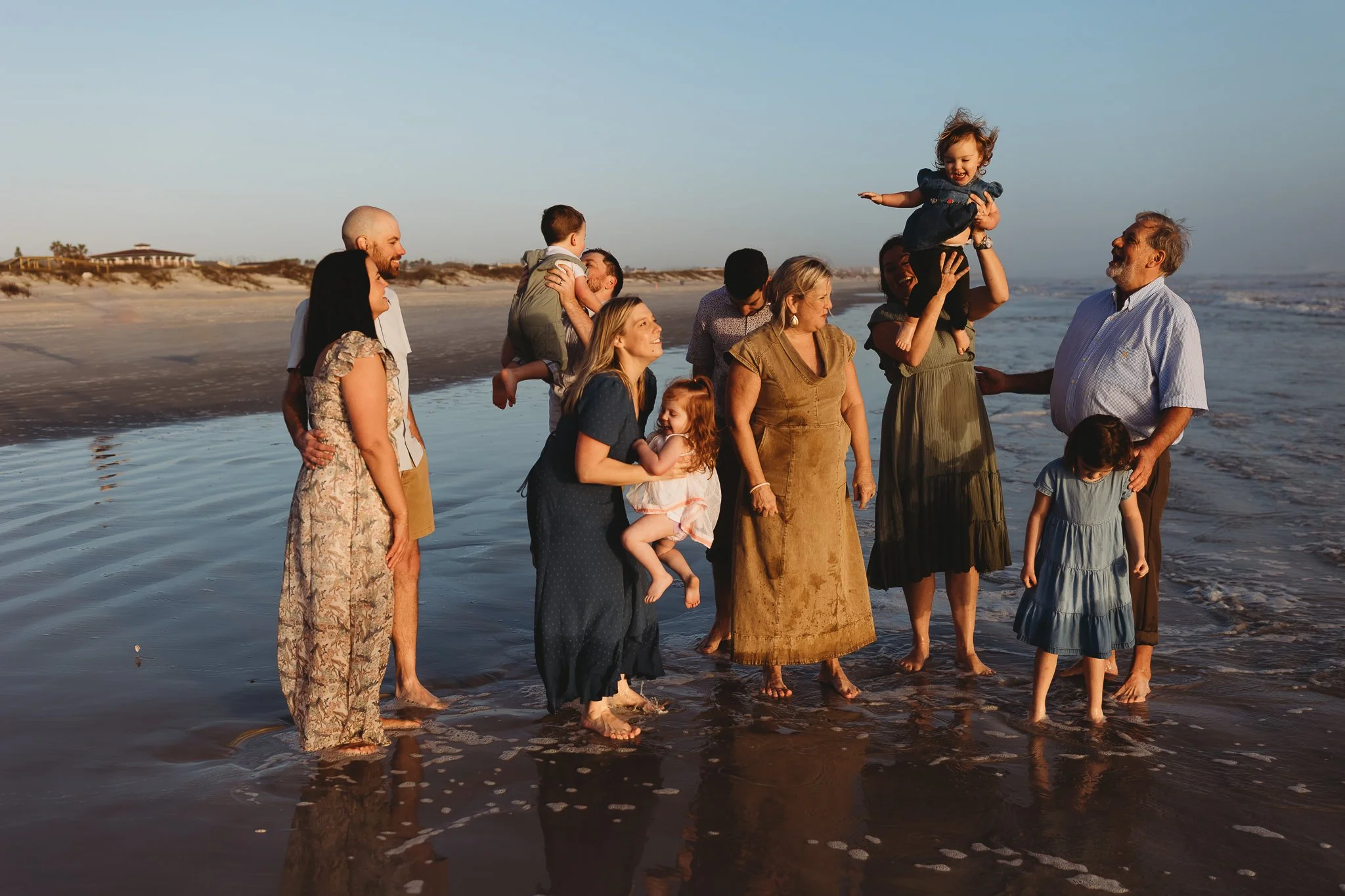 a family playing in the ocean during a family session