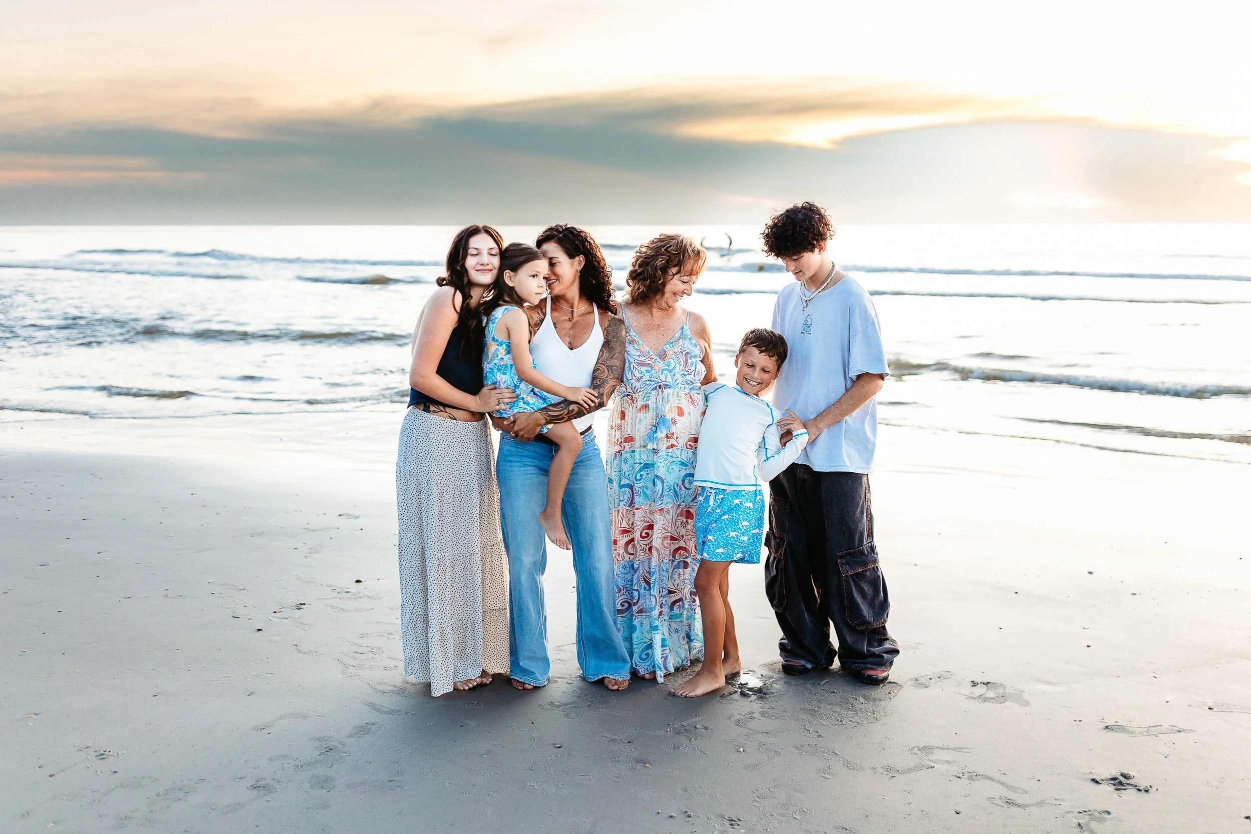 family in casual attire on the beach at micklars landing during sunset