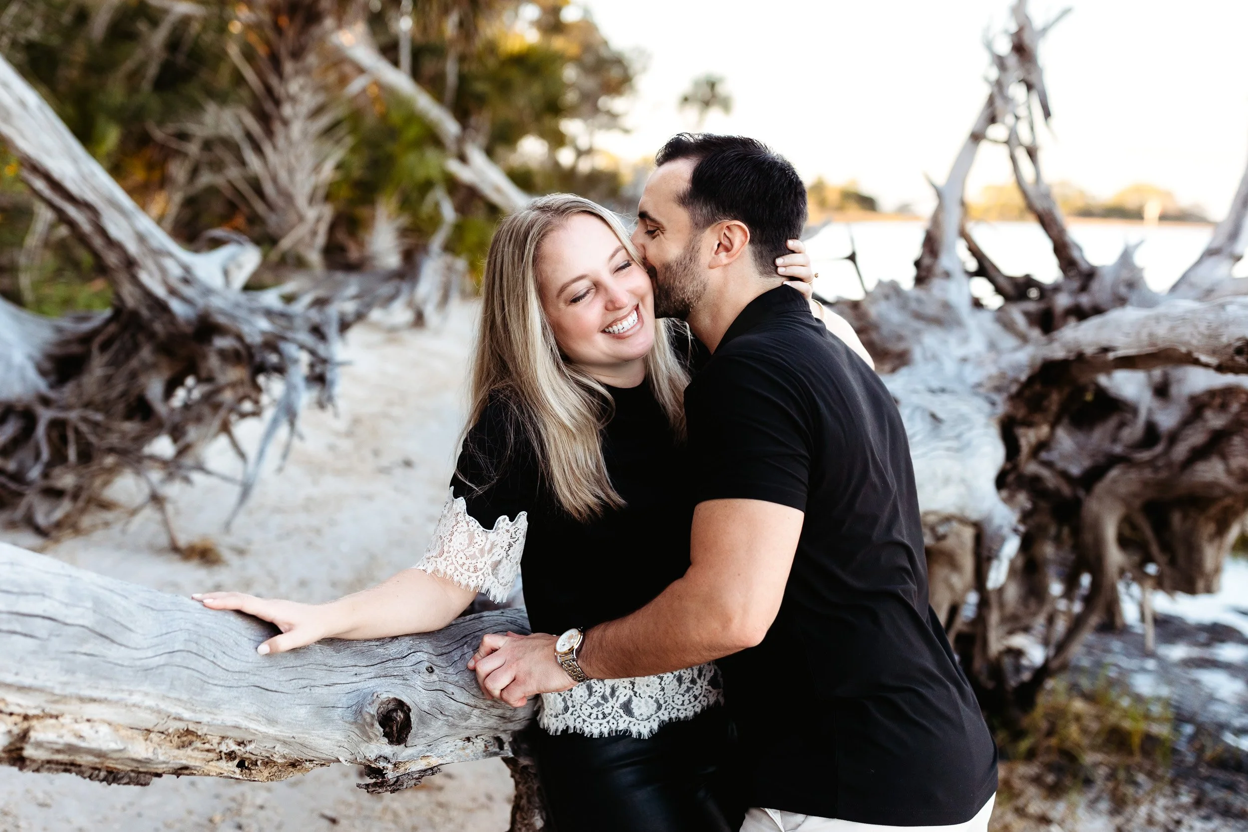 engaged couple laughing  along the water