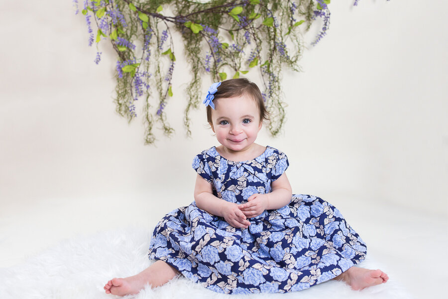 one year old in front of floral vine backdrop