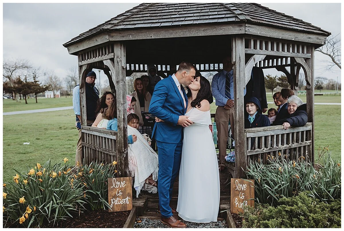 cuple kissing after getting married outdoors on a rainy day