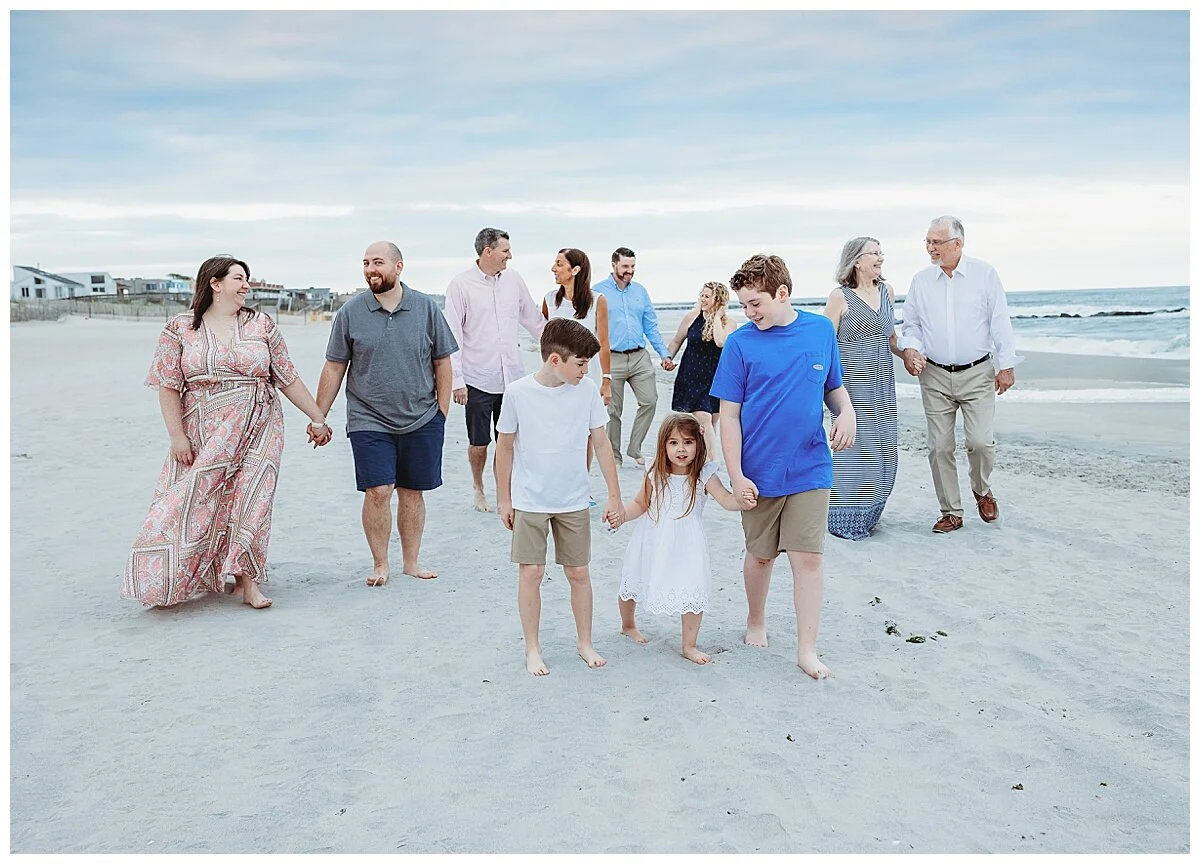 multi generational family walking down villano beach at sunset candidly