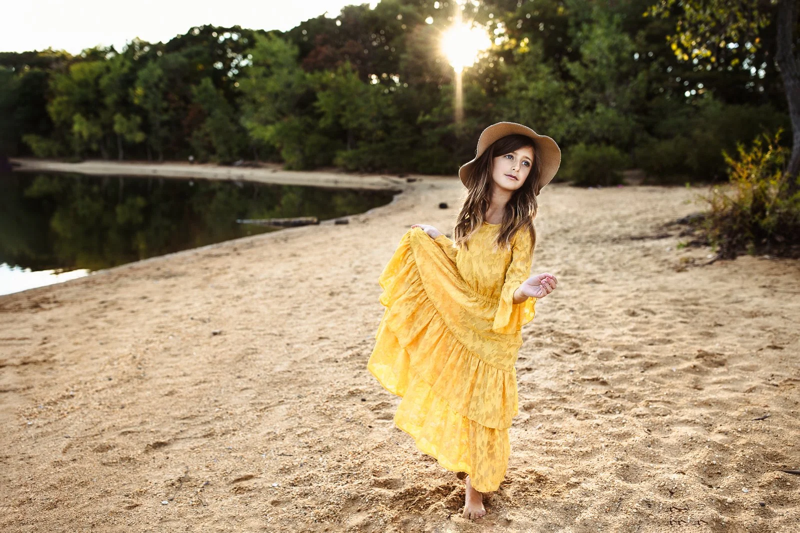 gilr in yellow maxi dress dancing at sunset on a beach