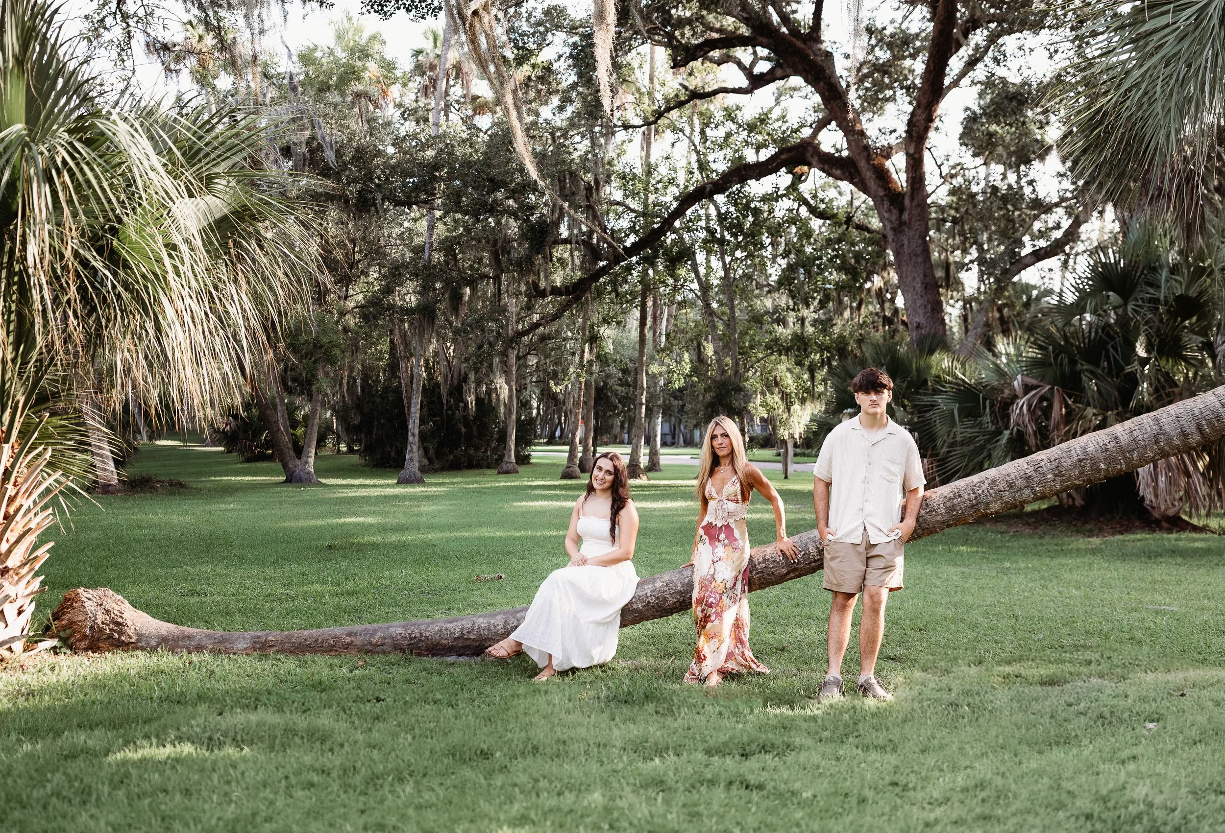 family seated on palm tree in a park for morning college photos
