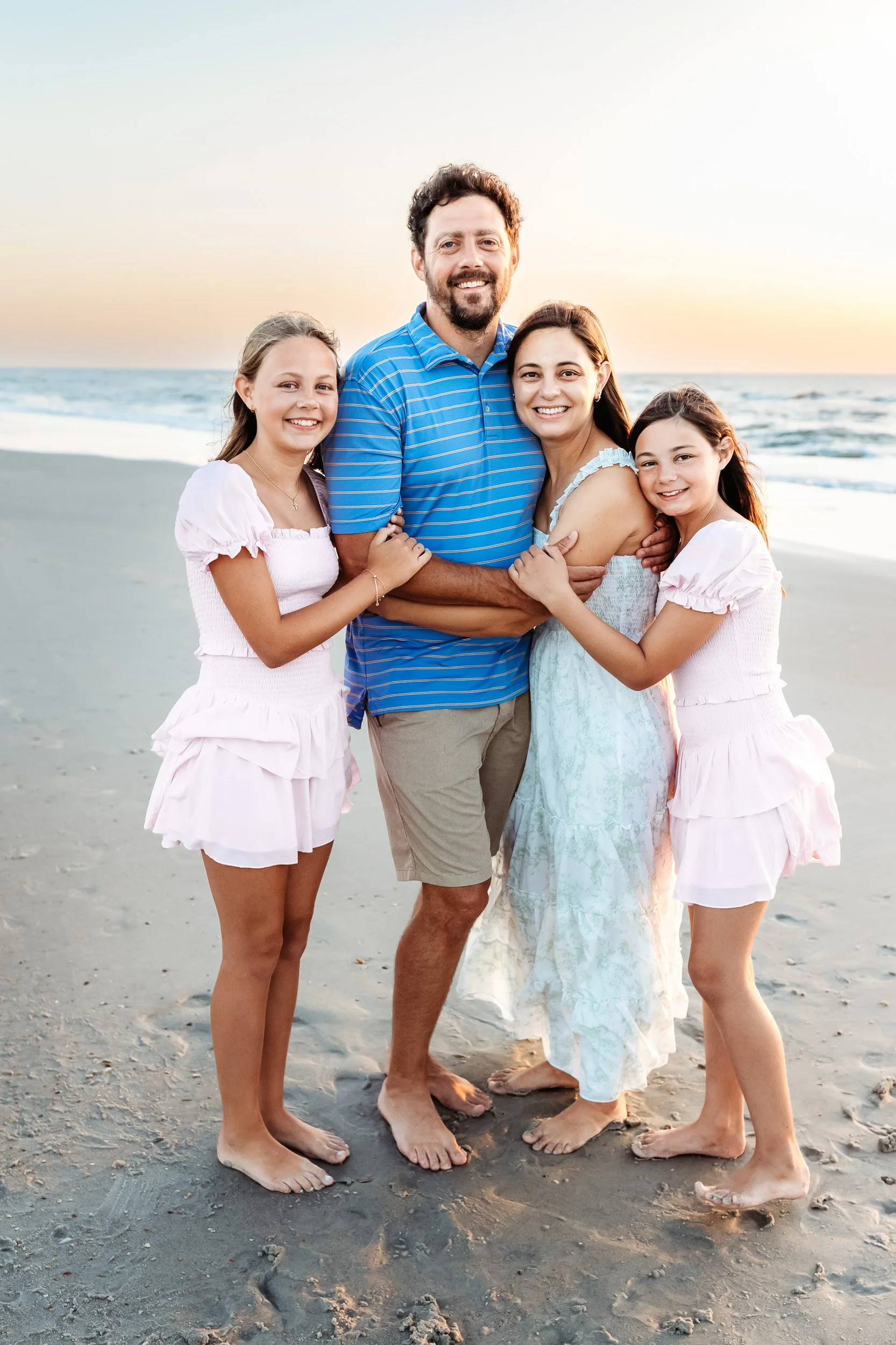 daily with tween girls in love shack fancy sets on the beach at sunrise for a family photo