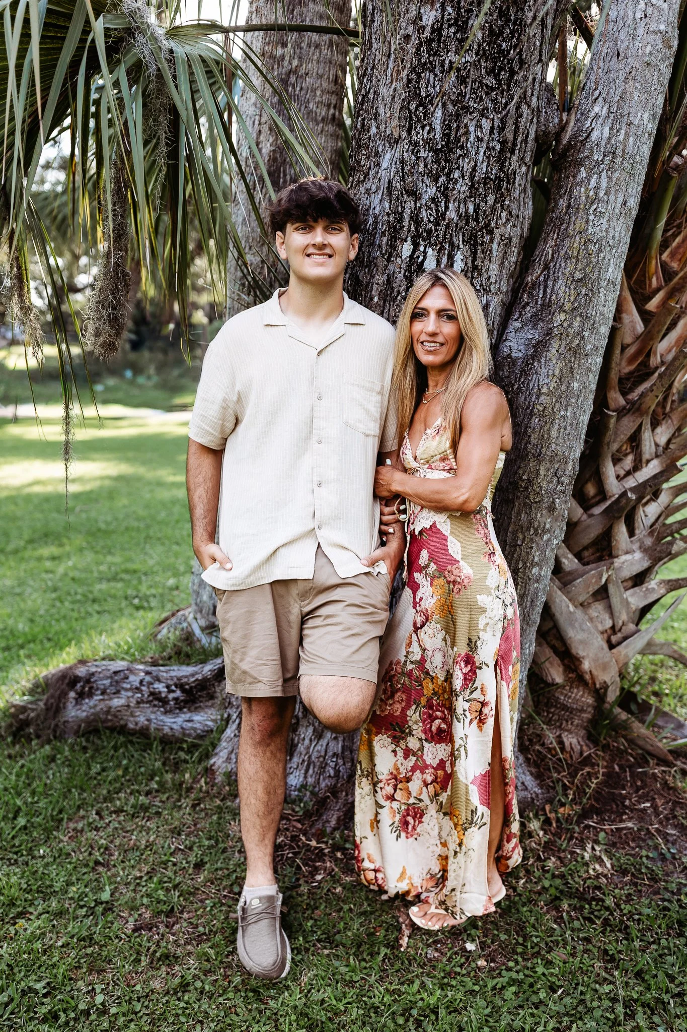 mother and son who is about to leave for college leaning against a palm tree in Neptune beach area for a photo