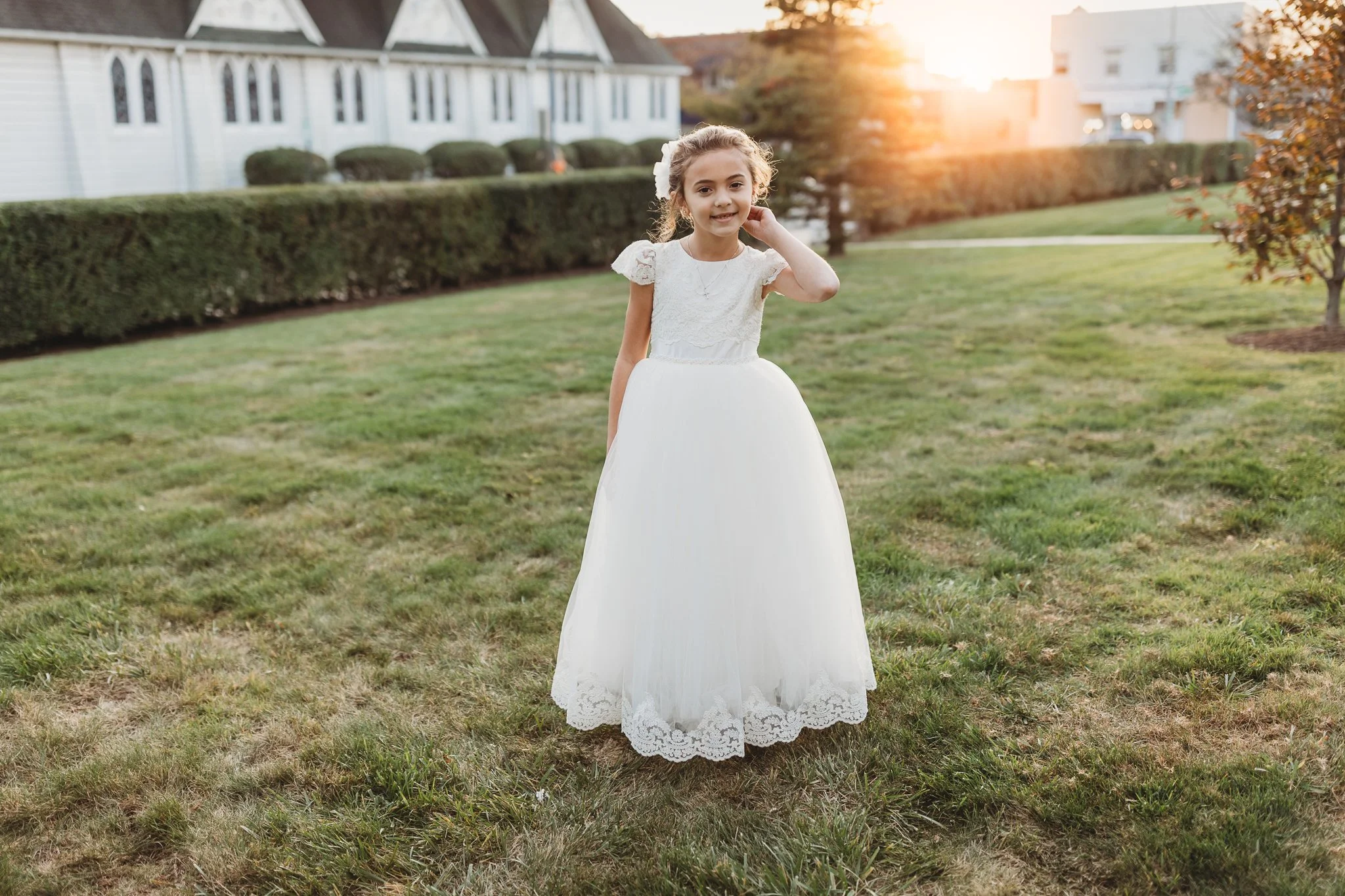 girl in ivory communion dress at sunset in front of dress