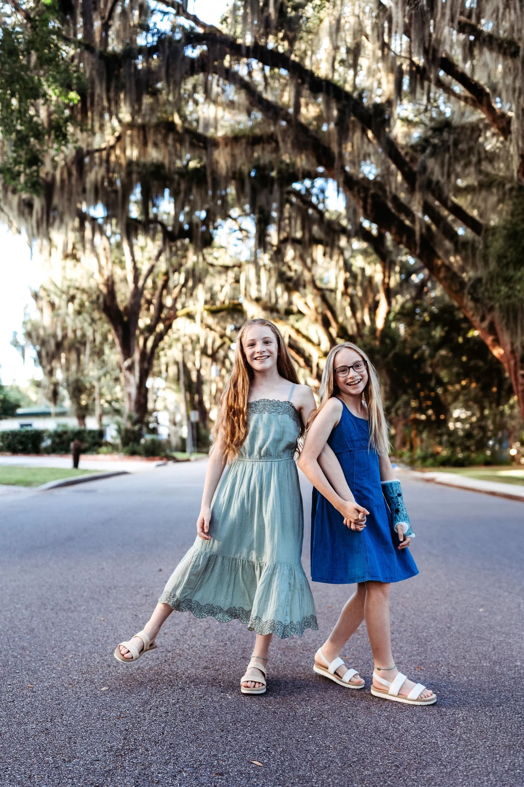 twin girls laughing as they pose for family photos