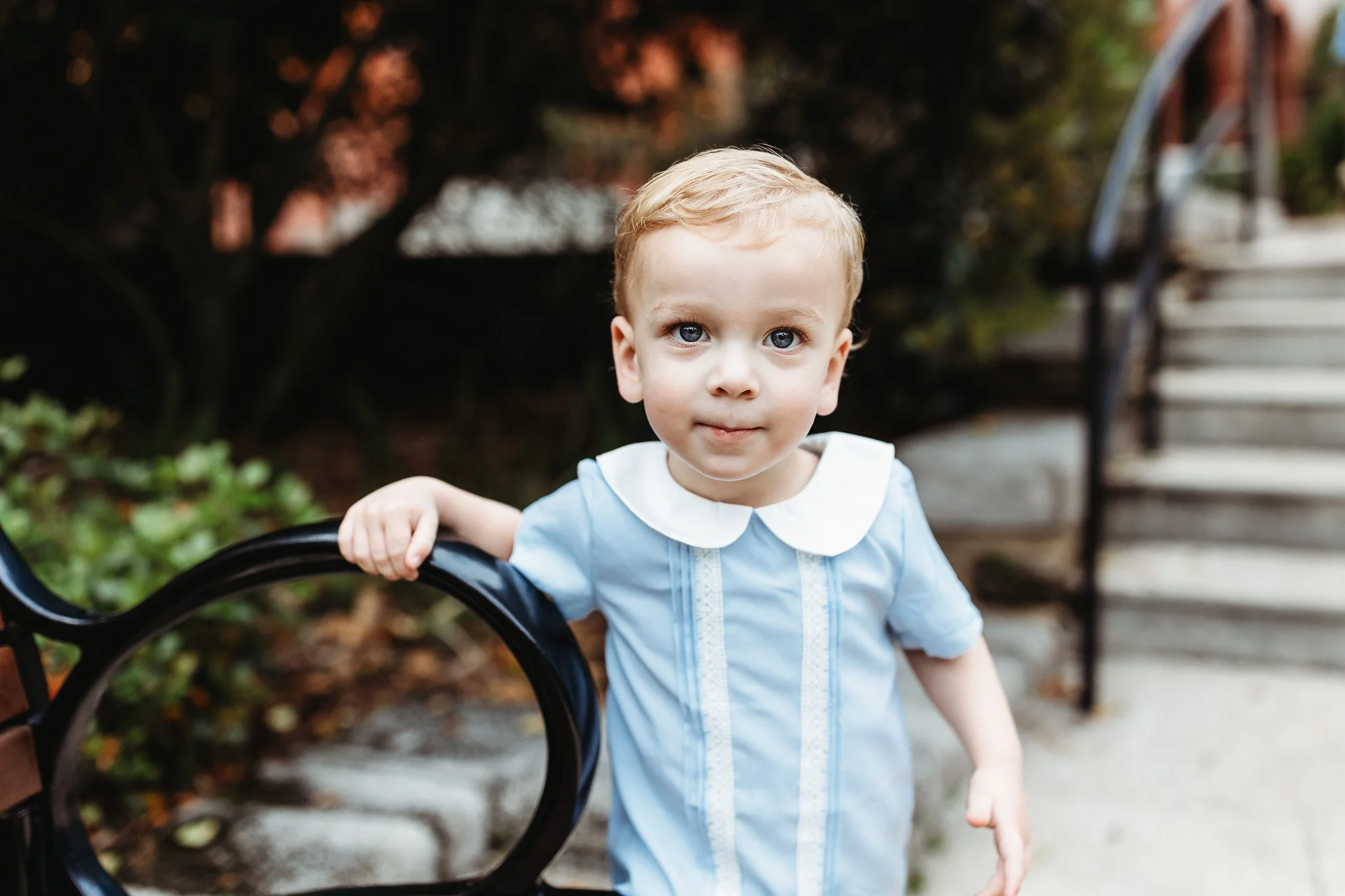 little boy in vintage blue shirt smiling at the camera