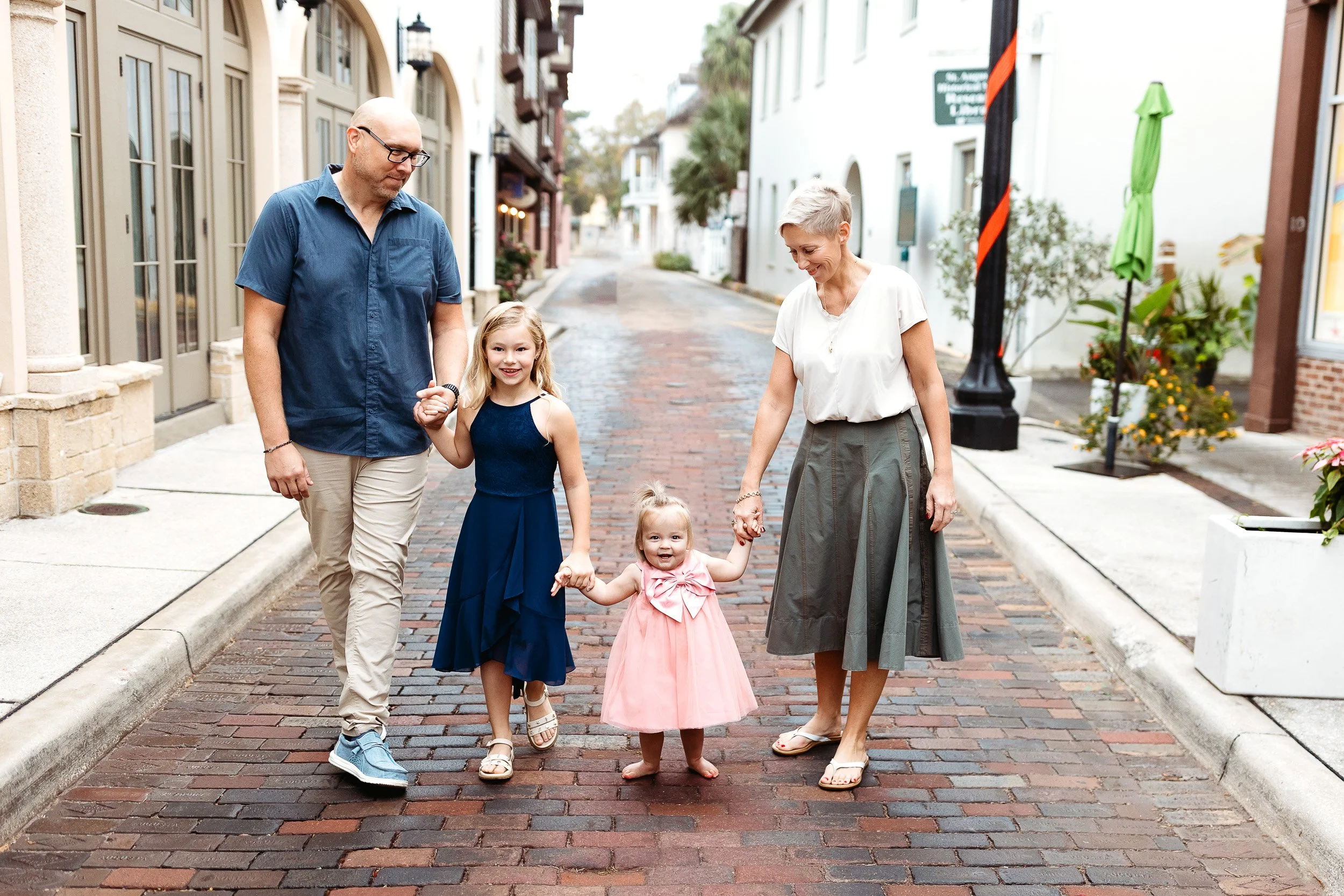 family walking down cobble stone street in st augustine for family photos