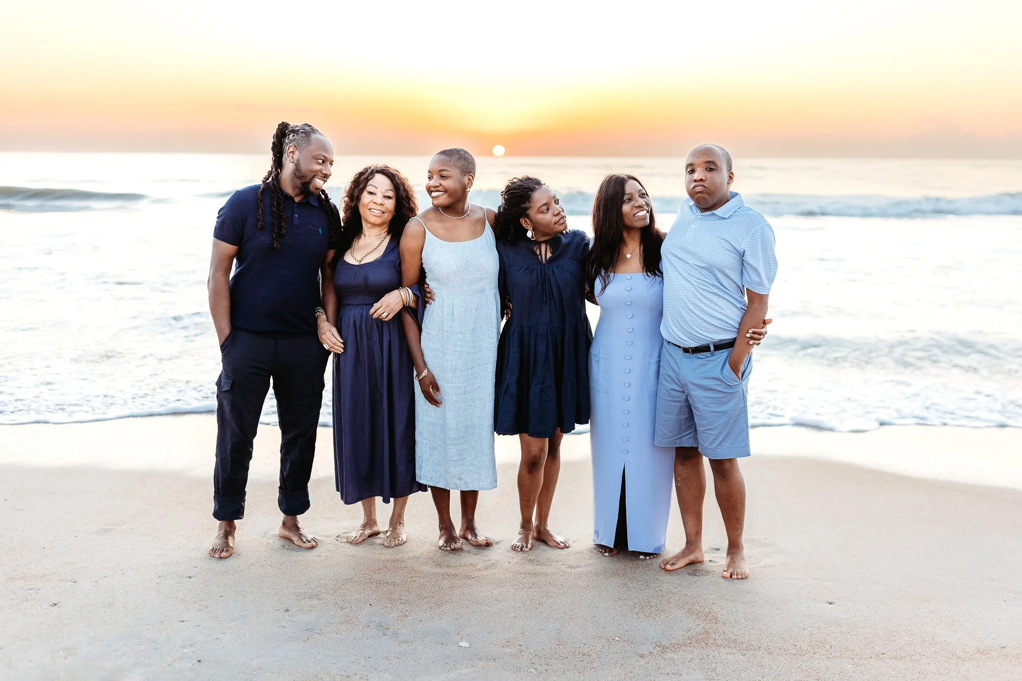 family sharing a quiet moment on the beach in soft sunrise light