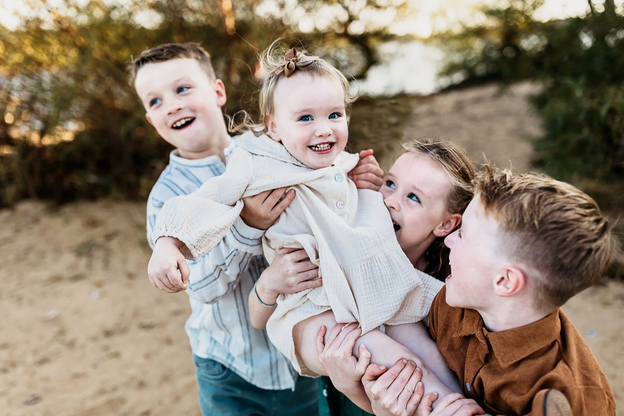 kids laughing and playing with toddle sister