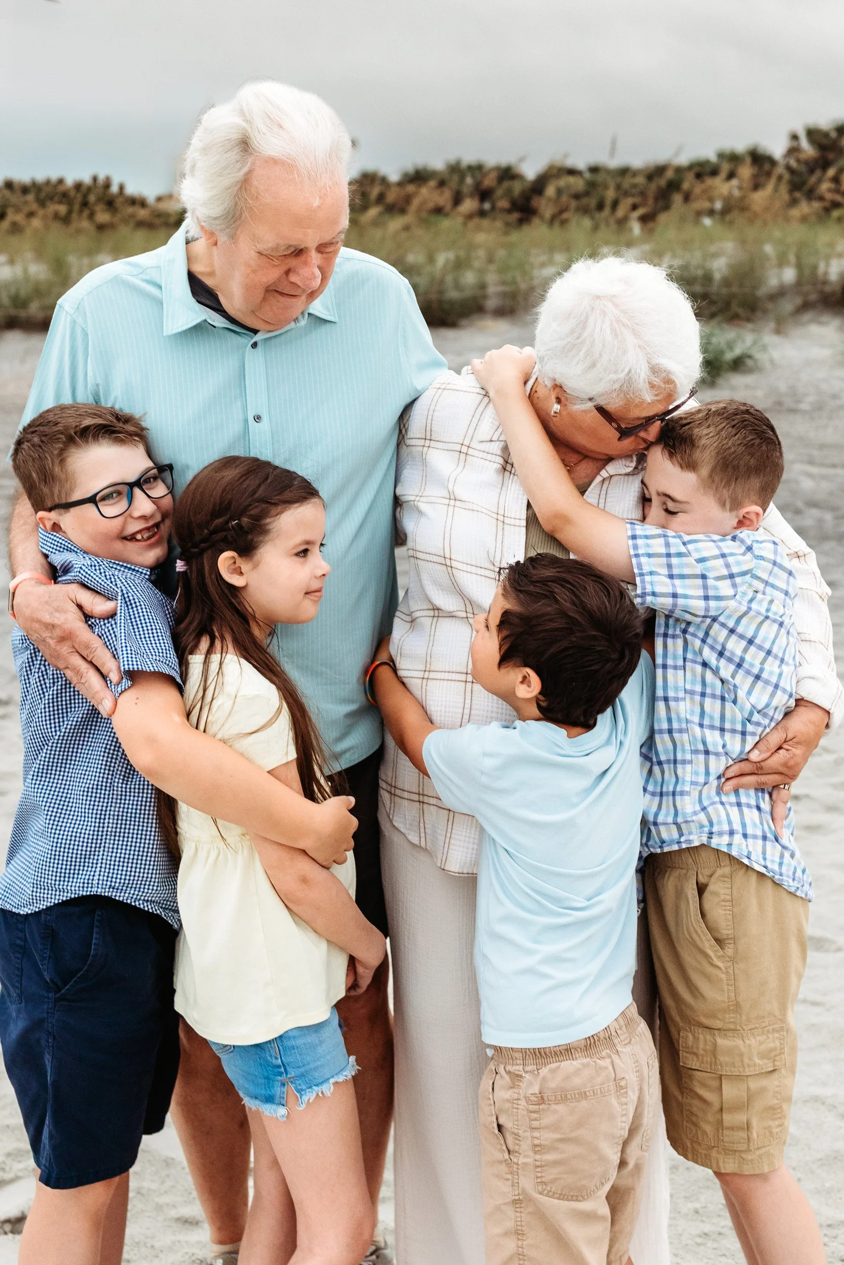 grandparents embracing grandchildren in a big and kissing them