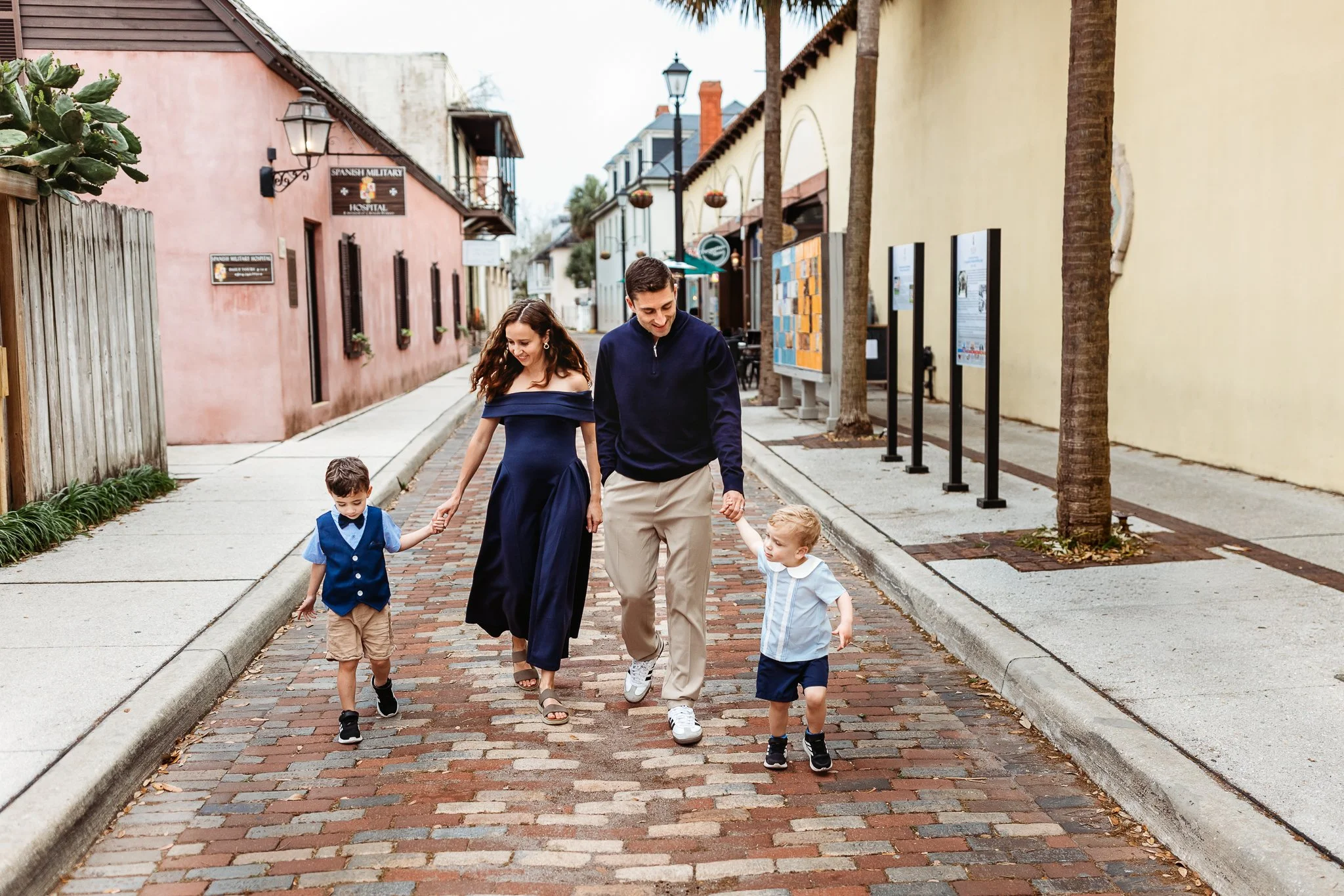 family walking on cobblestone street and laughing