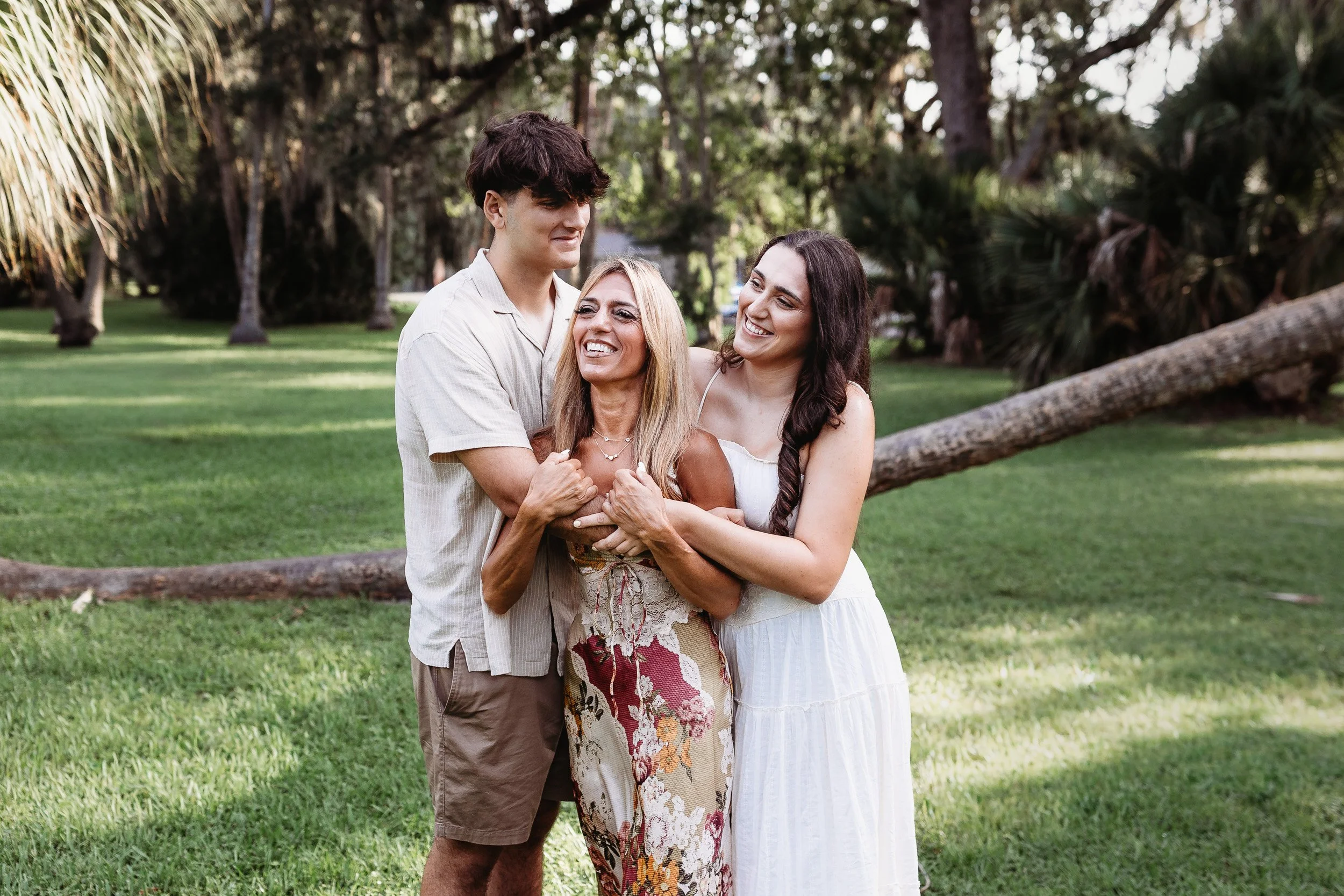 family embraced and laughing in Johansen park for family photos