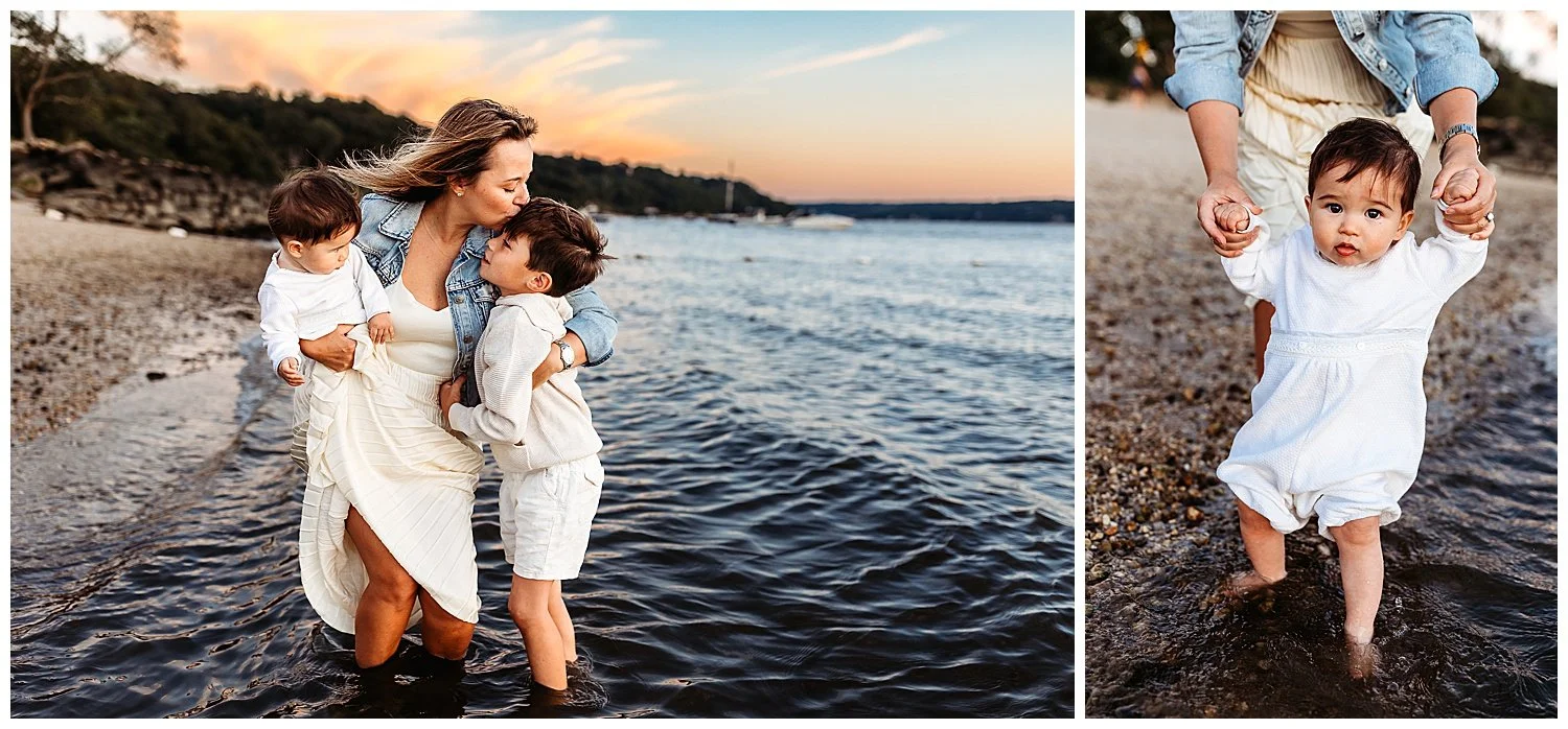 baby boy in vintage white jumper with toes in water at sunset and mom holds his hands