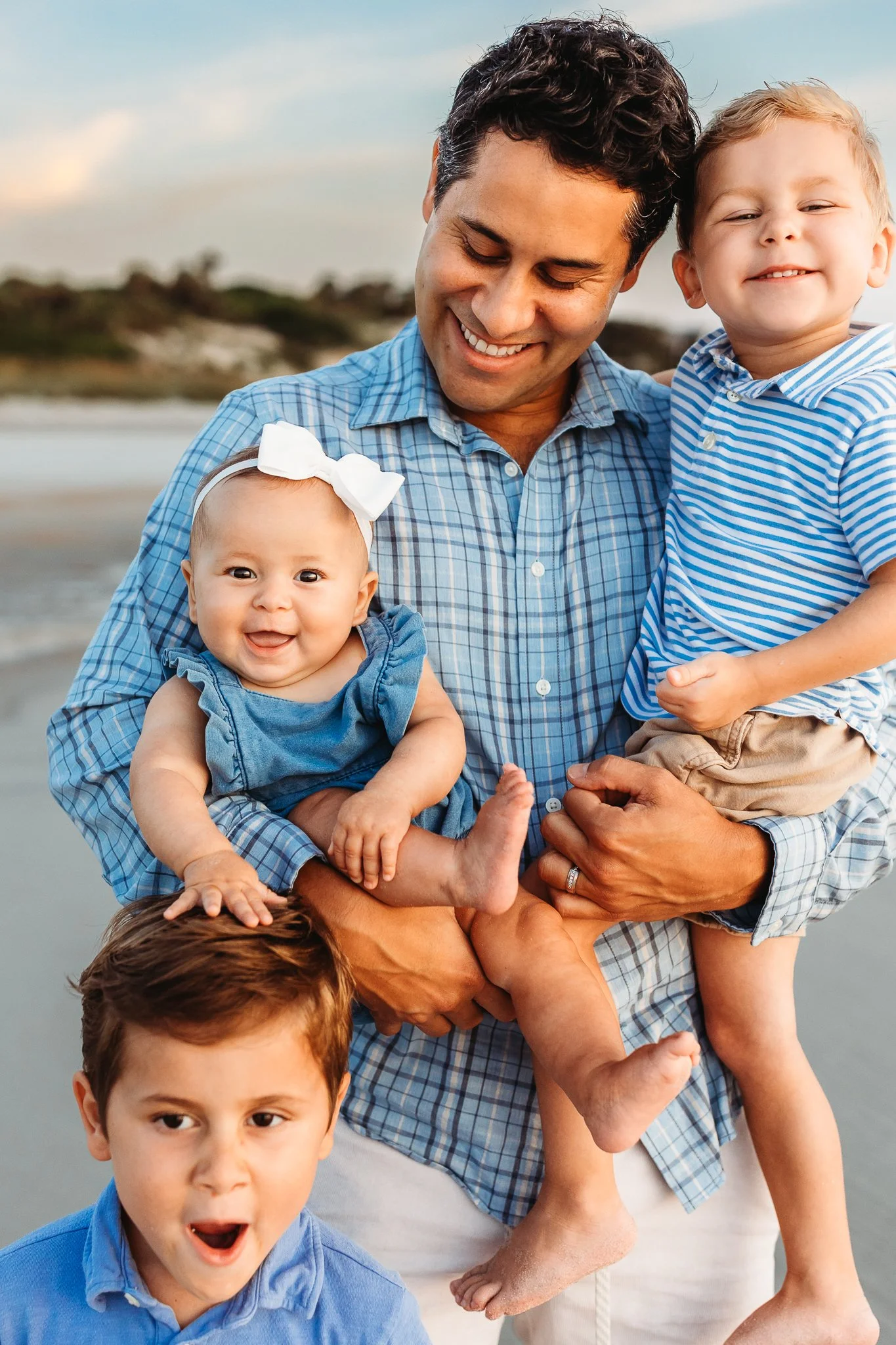 dad holding all three of his kids and they are all laughing