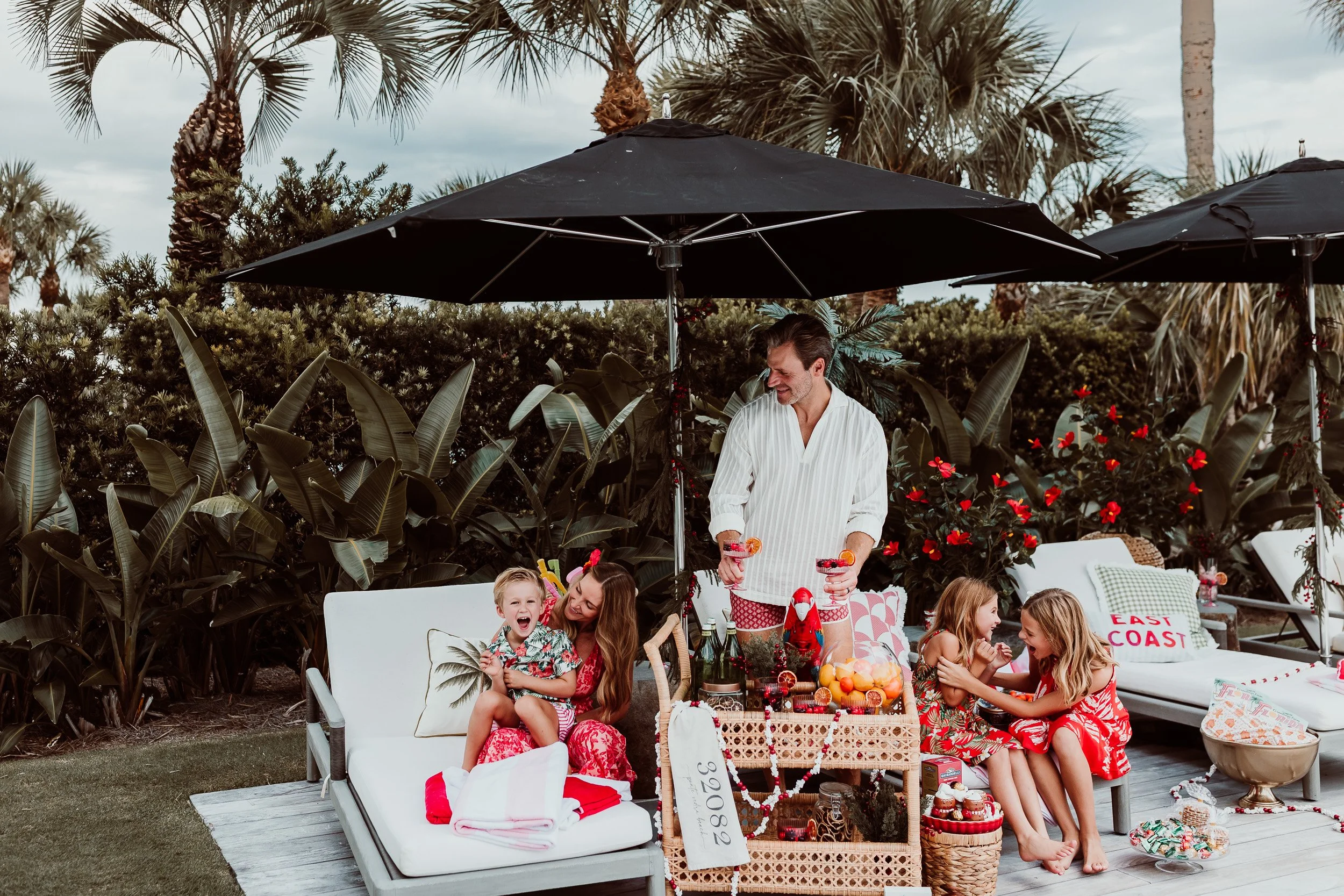 Family portrait with colorful tropical clothing and blue pool water