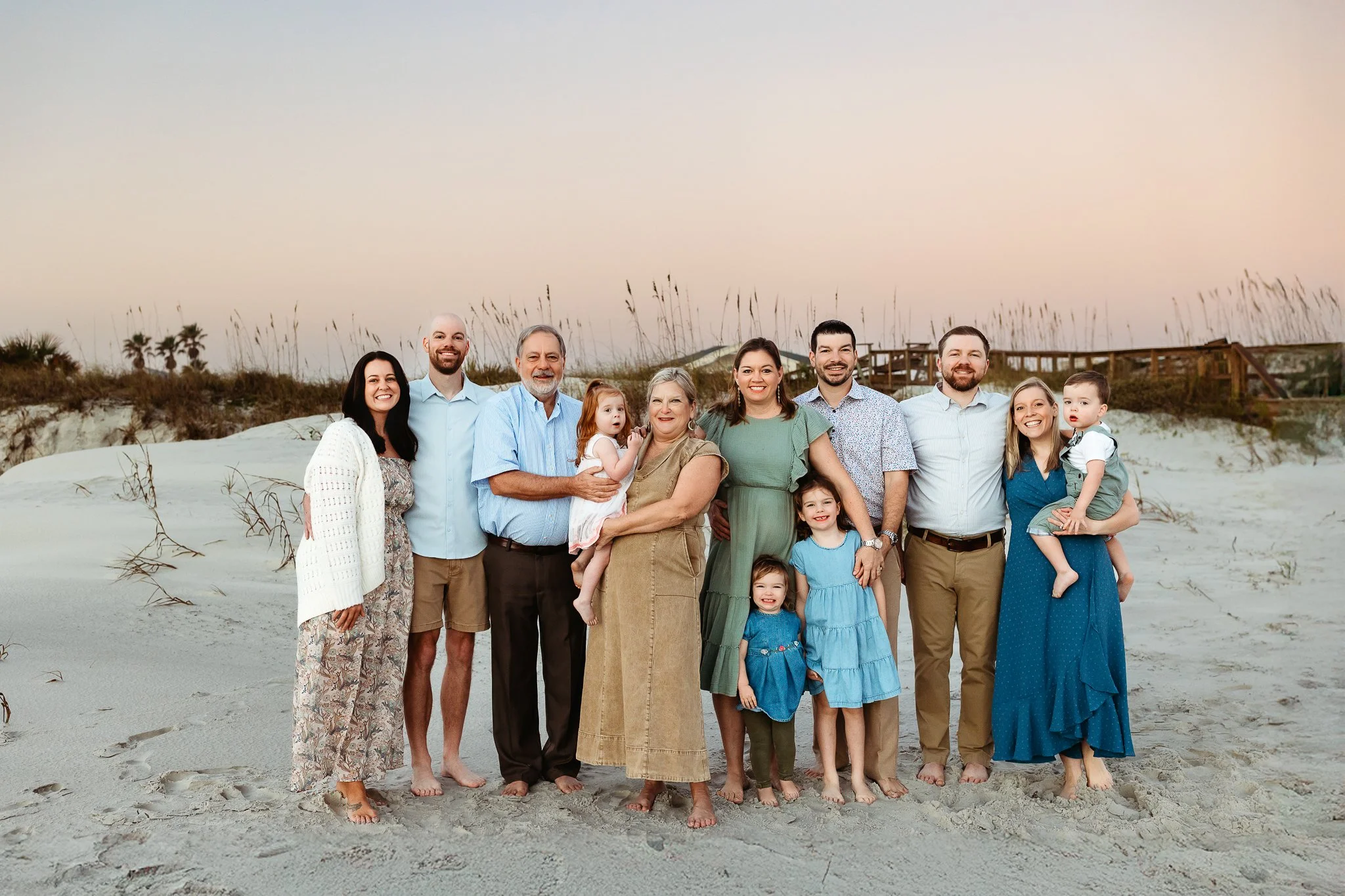 Extended family standing together at sunrise on Crescent Beach during a relaxed milestone family photography session.