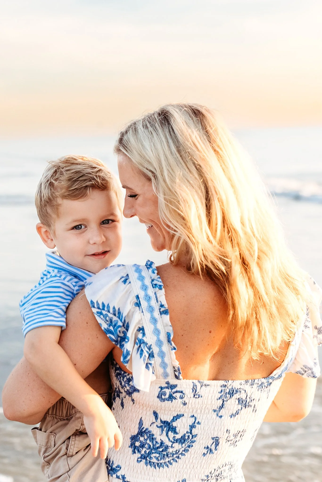 mother holding baby boy who is looking over her shoulder at the camera