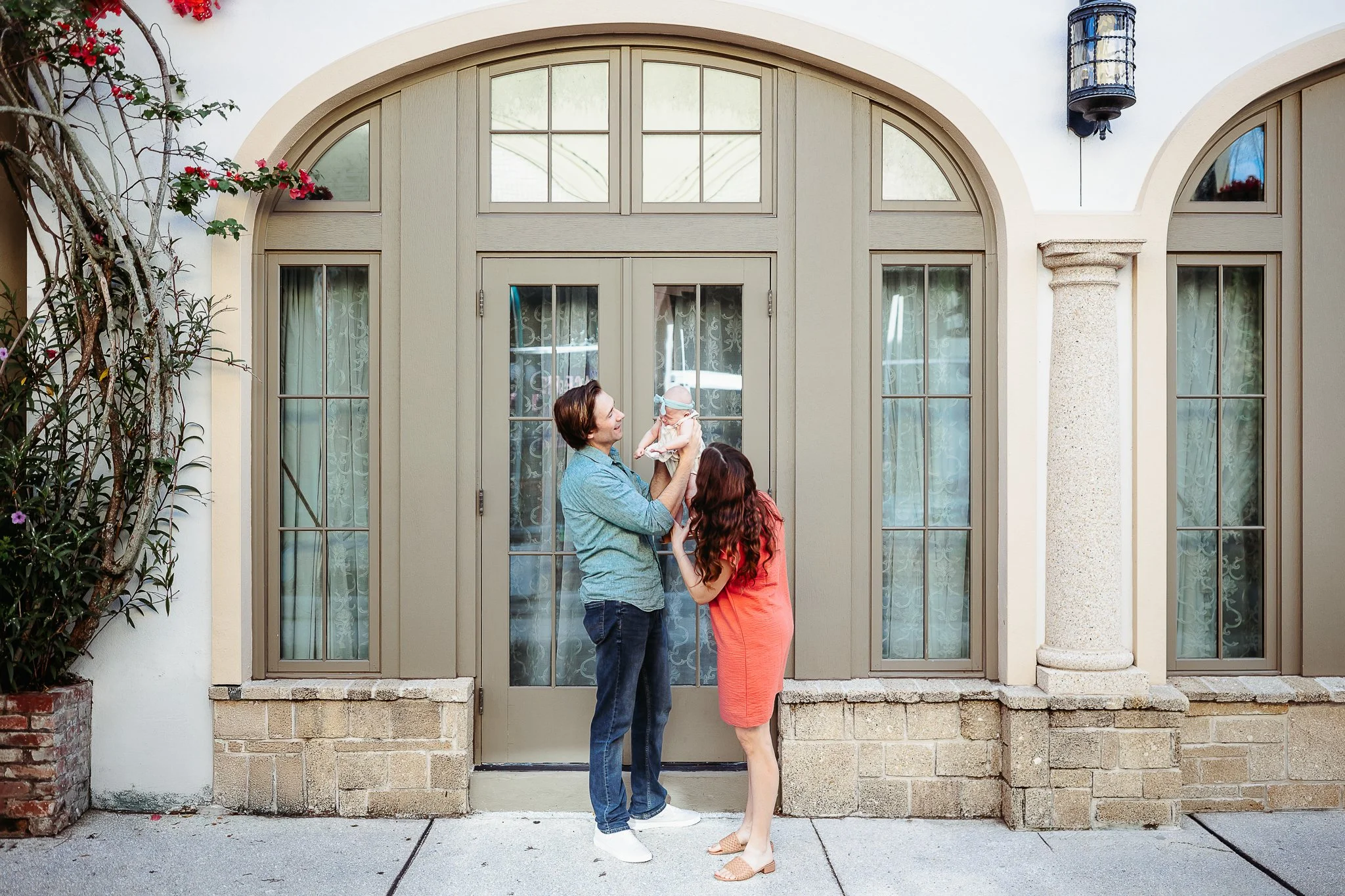 couple playing with baby in historic downtown st augistne for vacation family photos with their baby