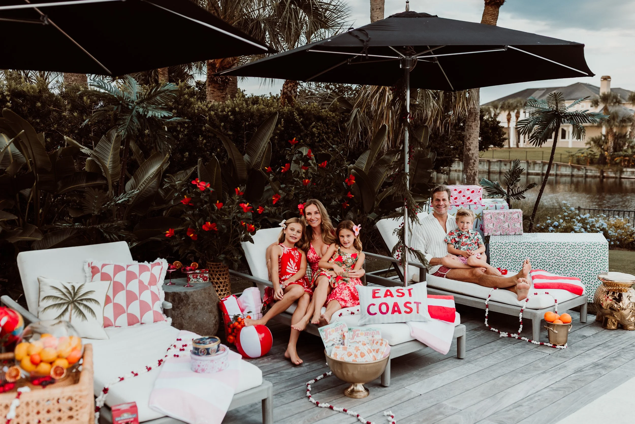 family in tropical outfits gathered beside their backyard pool