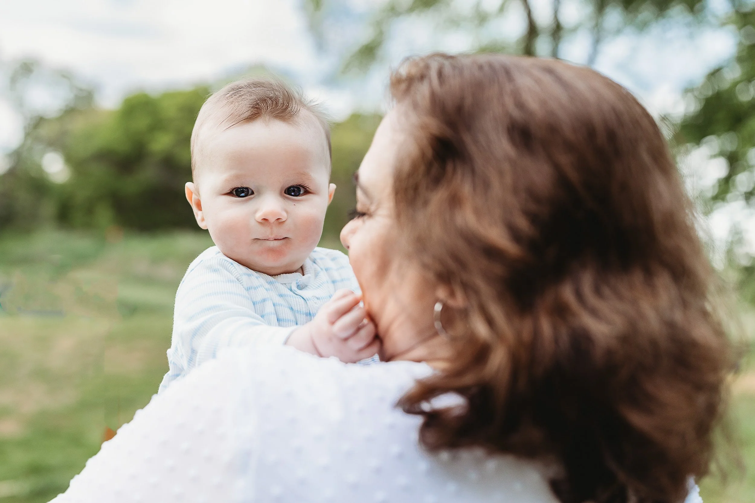 close up of a baby boy lightly touching grandma's face in st augustine area 