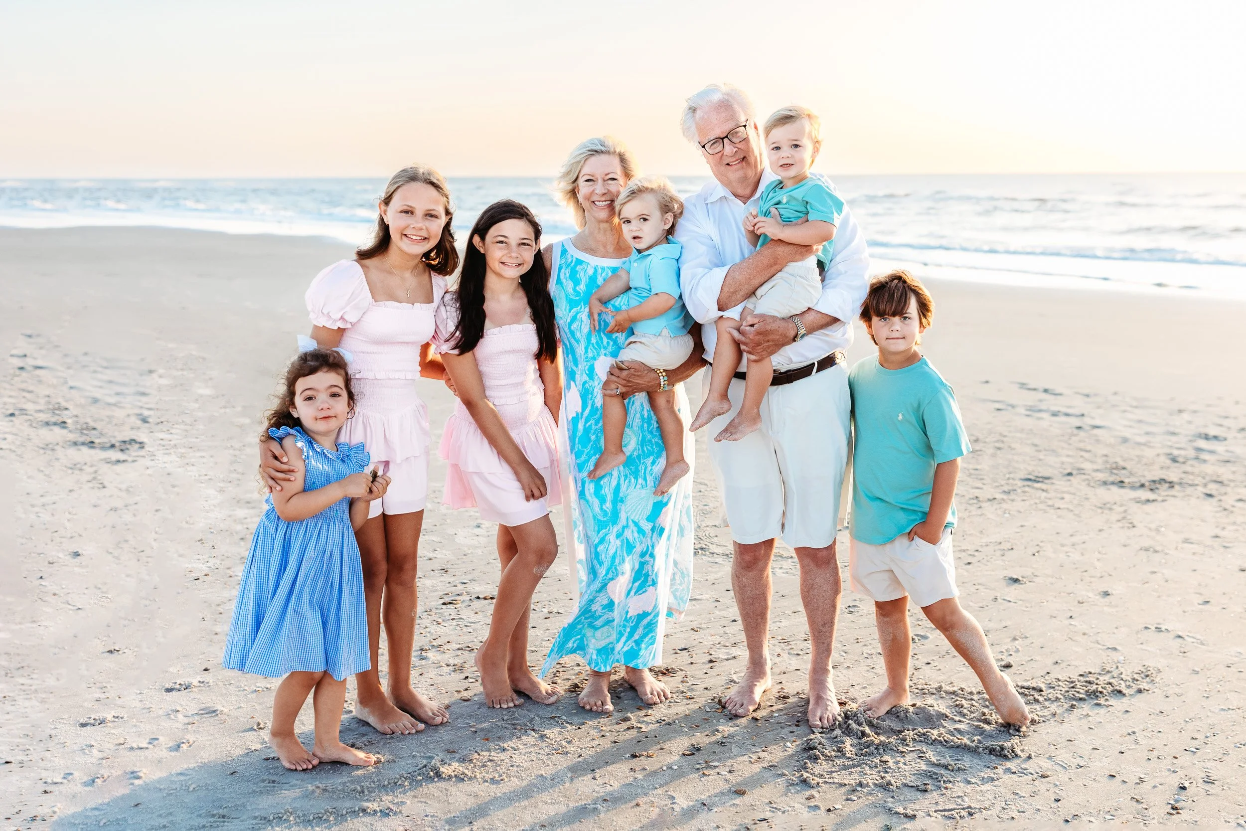 grandchildren with grandparents on the beach at sunrise for a family photo session near the Ponte Vedra inn and club