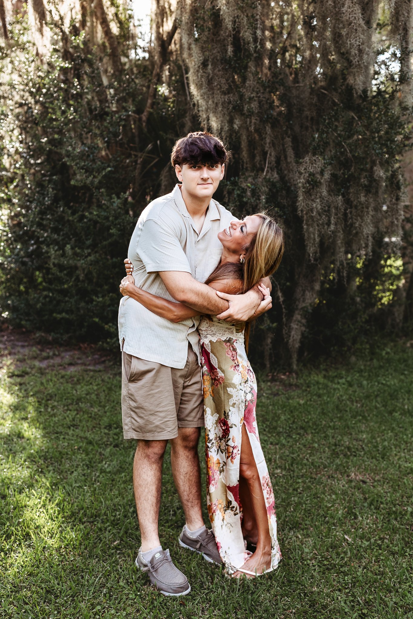 mother embracing her son and looking up at him and laughing before he leaves for college
