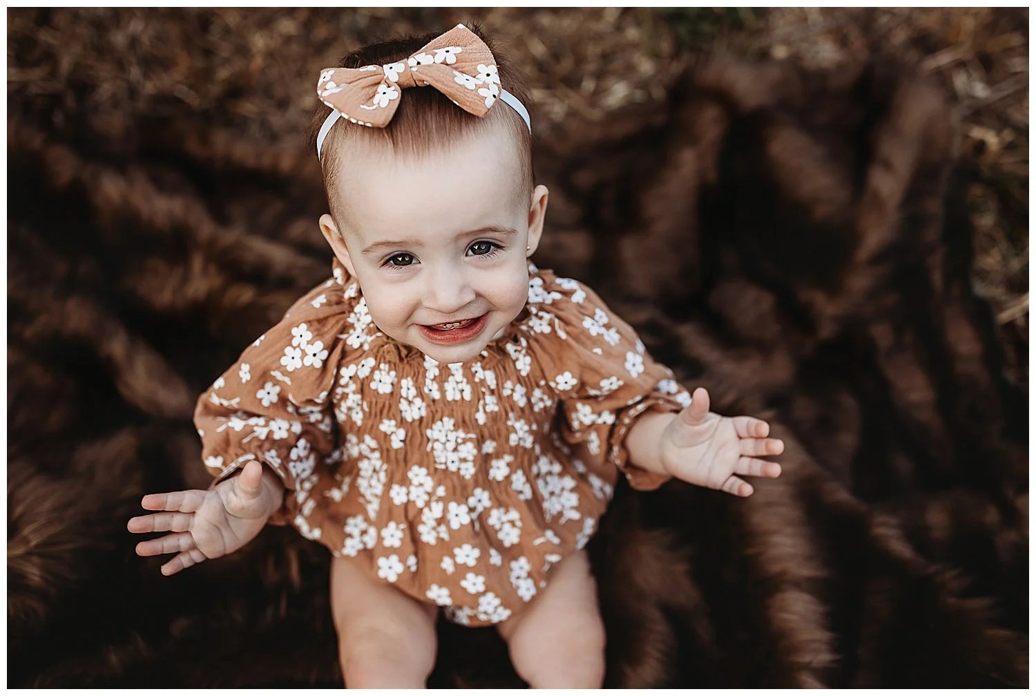 toddler girl in st augustine wearing brown romper for birthday photos