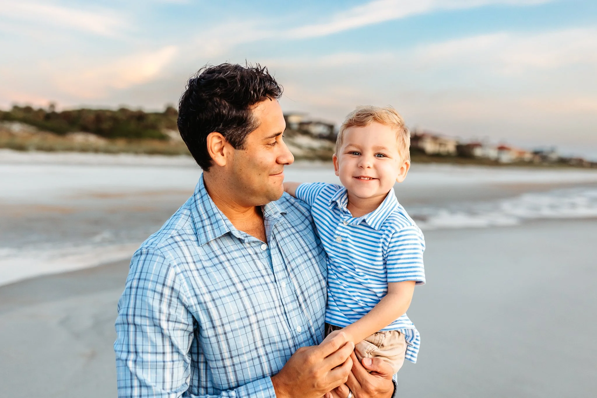 dad holding son and looking at him while he laughs