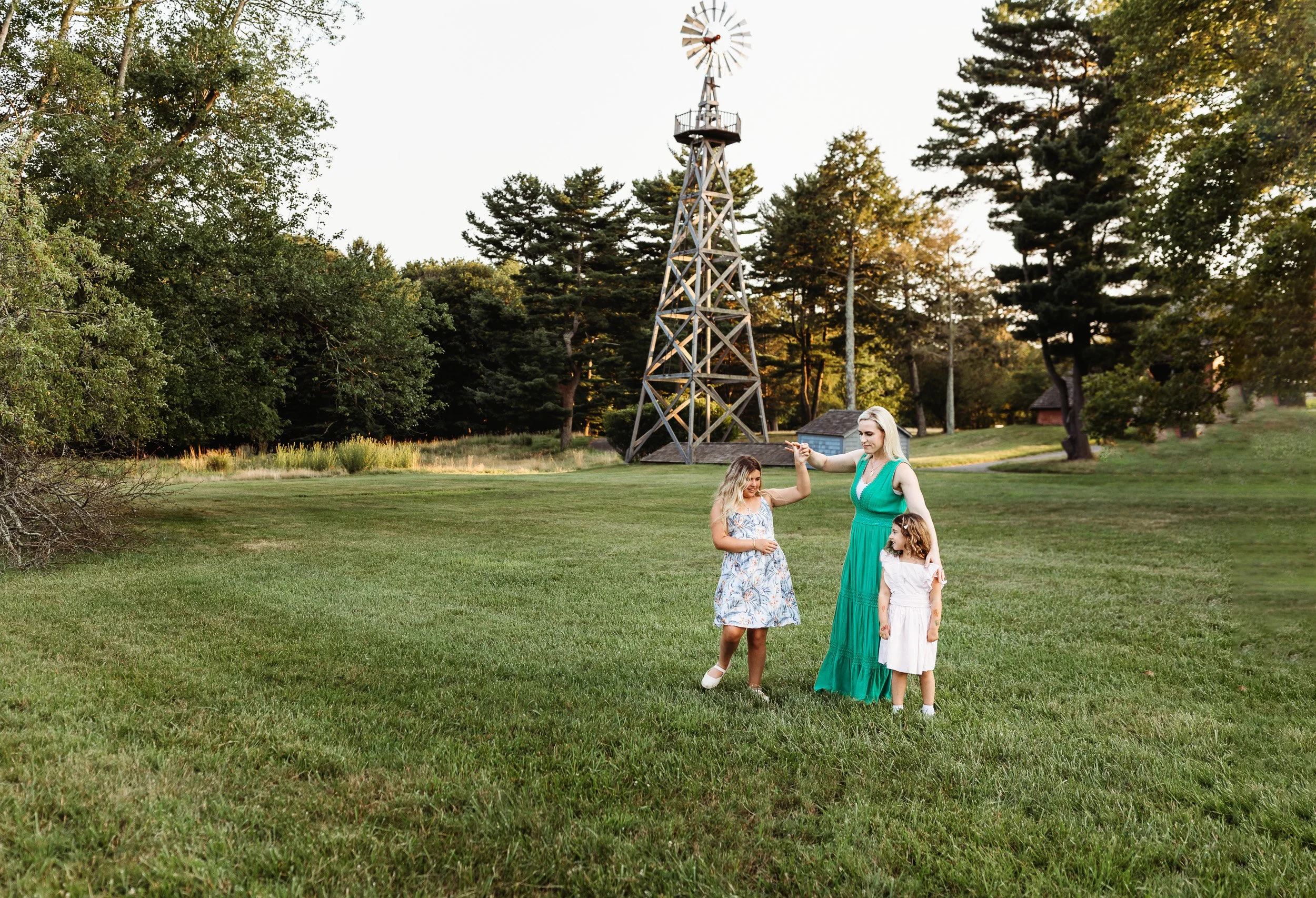 mother twirling tween daughter and toddler daughter is watching