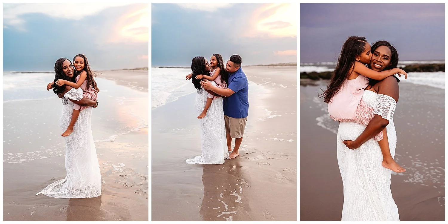 mom holding little girl on pregnant belly at sunset