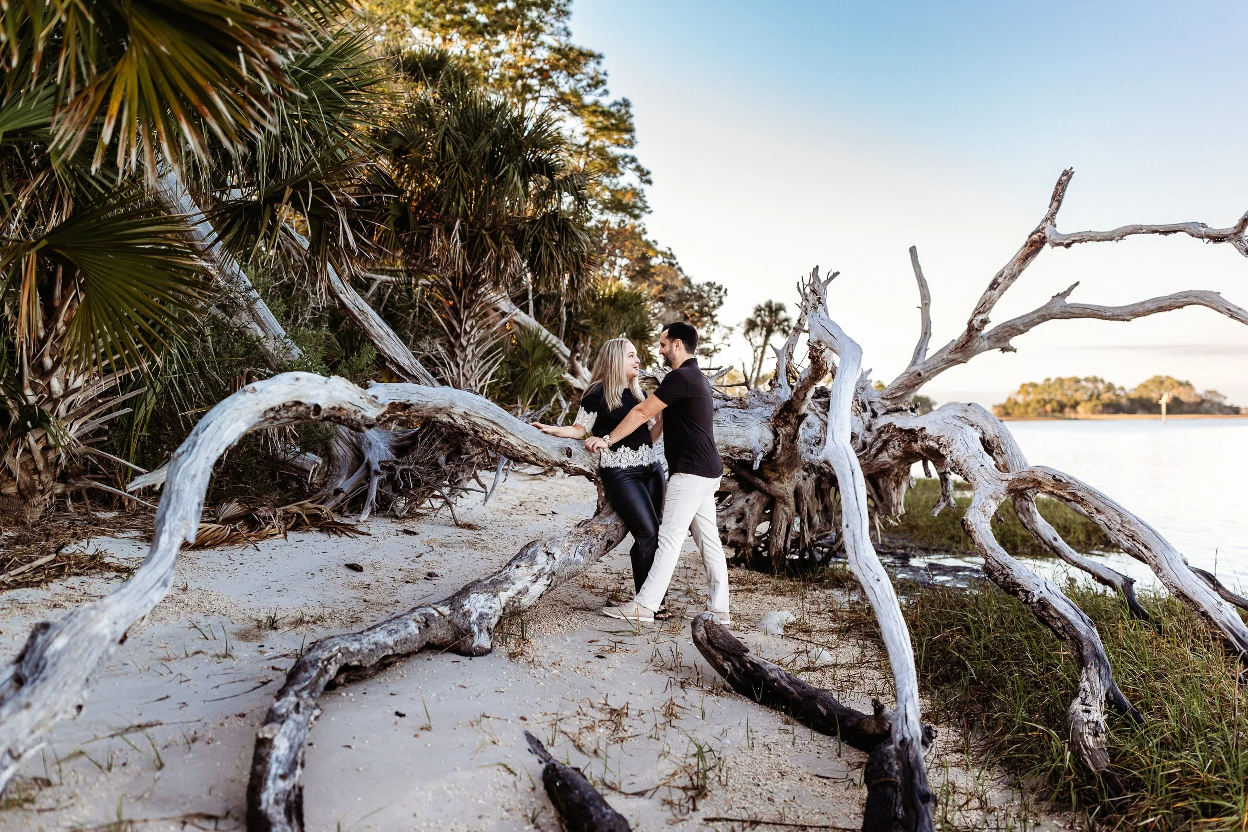 couple leaning on driftwood after getting engaged