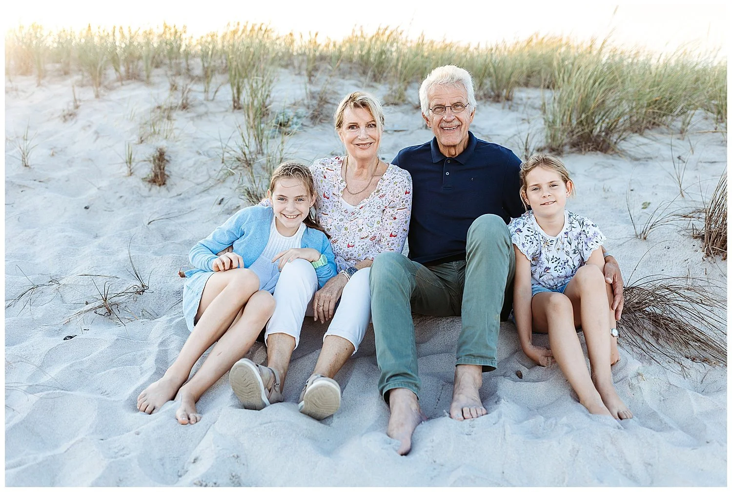 grabdparents seated in front of a dune with granddaughters