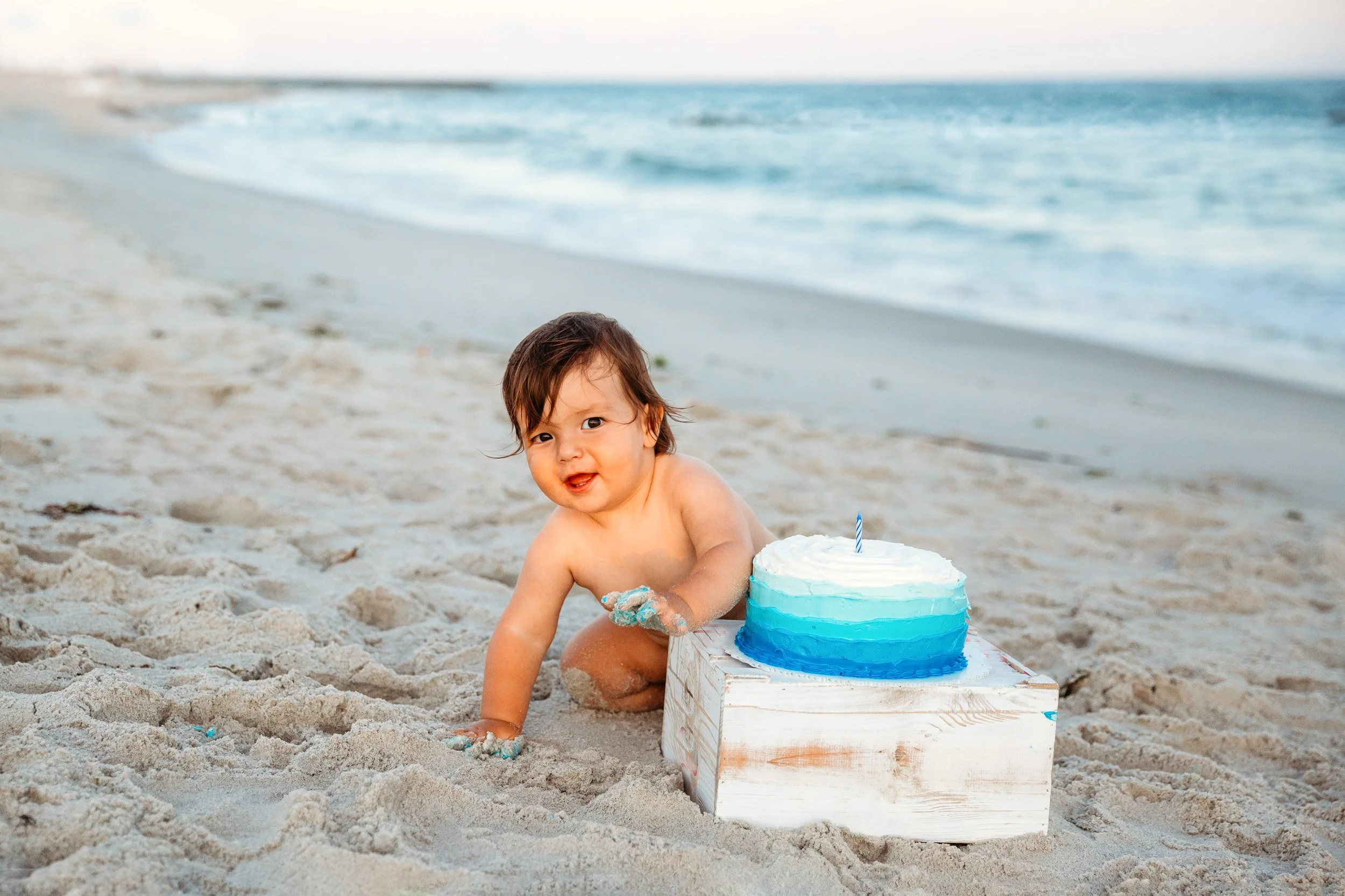 Baby smiling after cake smash on the beach at sunset in St. Augustine