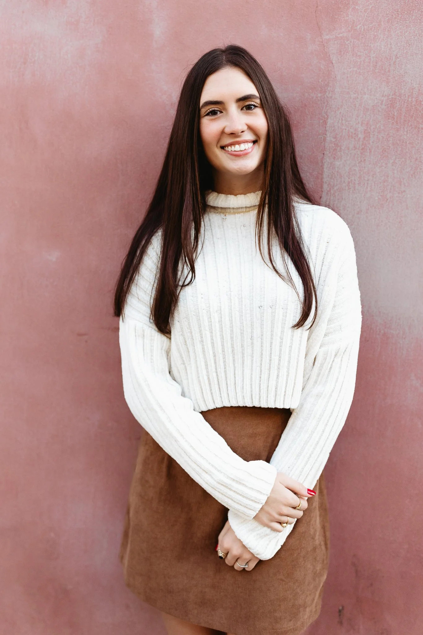 teen girl in front of a pink wall for a portrait
