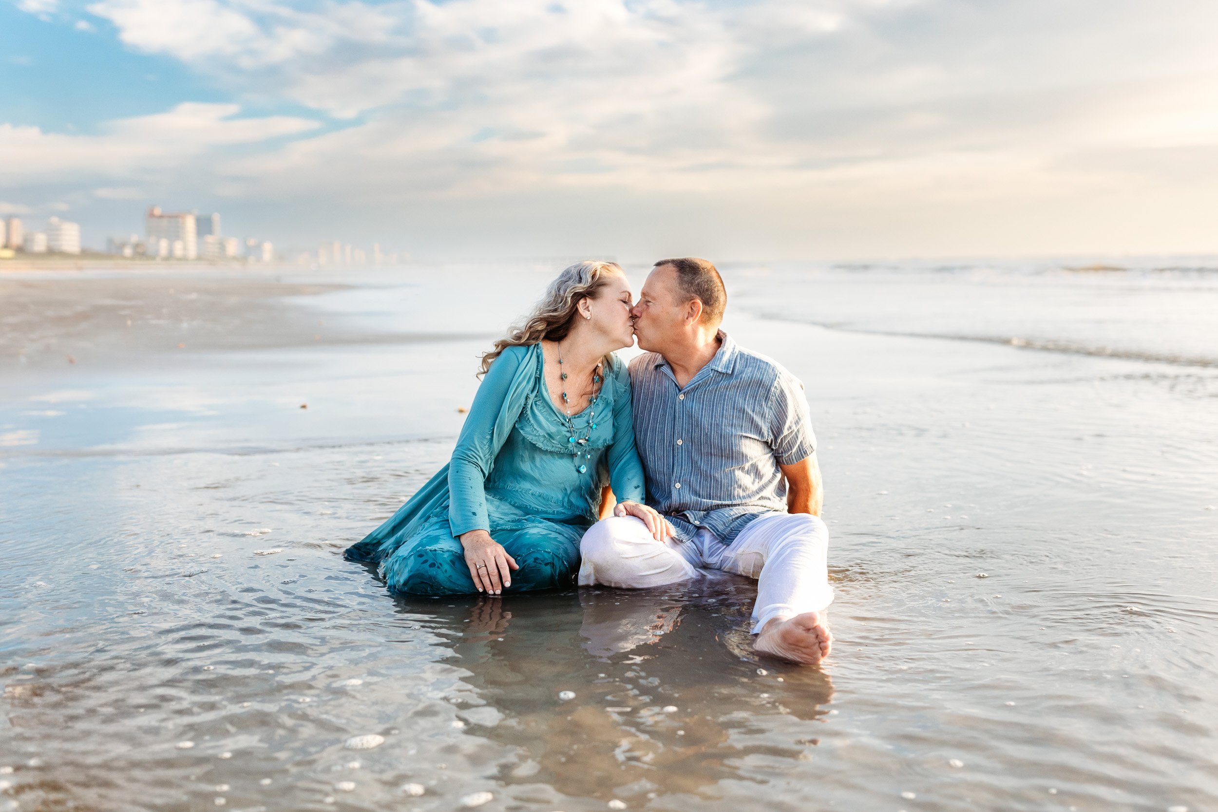 grandparents seated in a tide pool and they are kissing