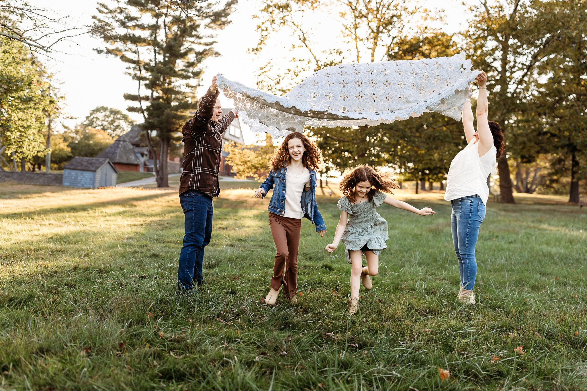 kids playing and running under a blanket in Fall outfits