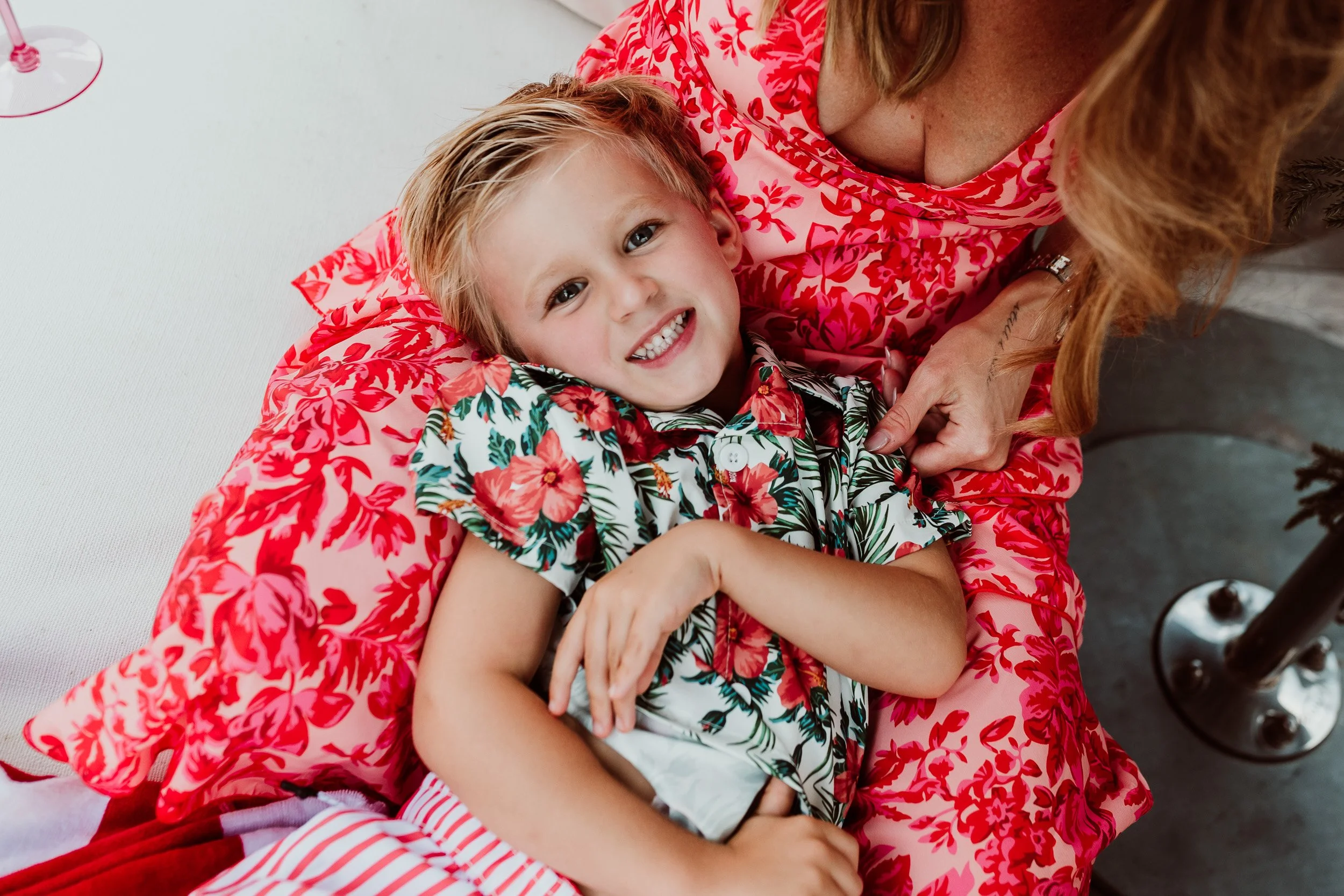 mom tickling little boy by the pool for holiday photos